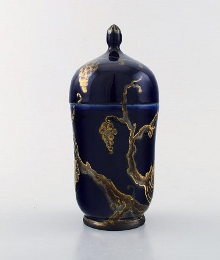 Karl Lindström and Nils Emil Lundström for Rörstrand. Lidded porcelain jar decorated with grapevines in gold on the beautiful dark blue base. Japanism, circa 1920.
In very good condition.
Measures 18.5 x 8.3 cm.
Stamped.