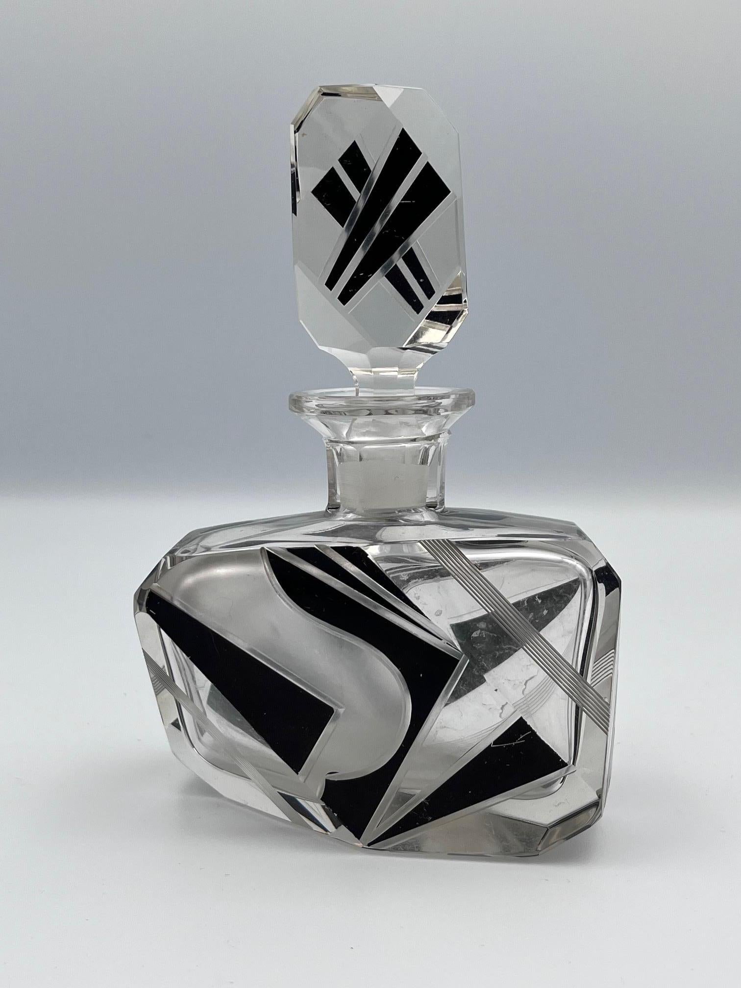 Cet exquis flacon de parfum Art déco de Karl Eleg est un mélange magistral de géométrie et d'élégance. De forme abstraite, son design complexe est rehaussé par des détails audacieux gravés, découpés et peints qui créent une impression de mouvement