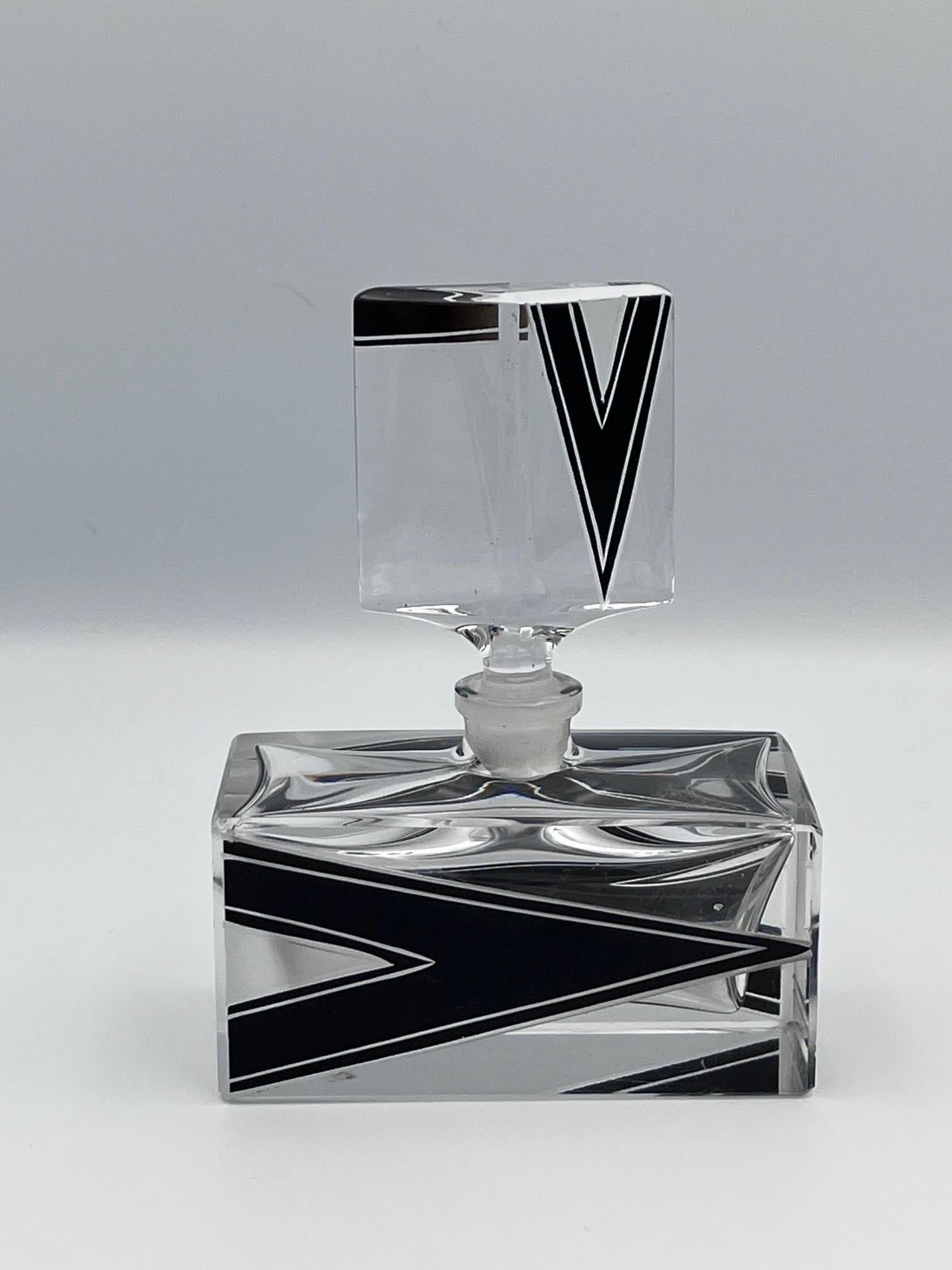 Questa rara e da collezione bottiglia di profumo Karl Palda Art Deco è un esempio straordinario di design in vetro ceco degli anni Trenta. Caratterizzato da un audace motivo a V chevron sul fronte e sul retro, abbinato a un elegante motivo lineare