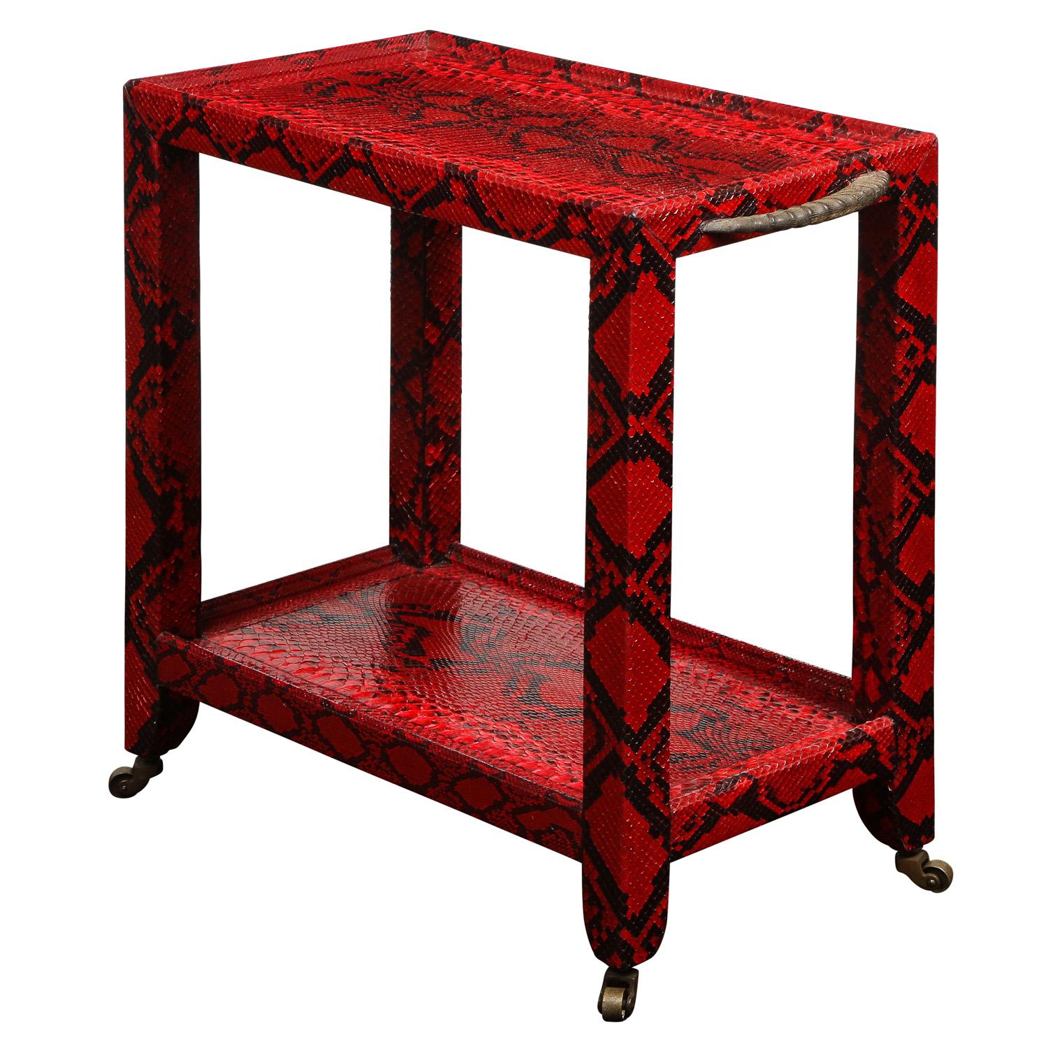 Unique 2-tier side table in red python with authentic horn handles with small brass castors by Karl Springer, American 1977 (label on bottom reads “Karl Springer 1977”). Fine materials and craftsmanship are the hallmarks of Karl Springer’s designs. 