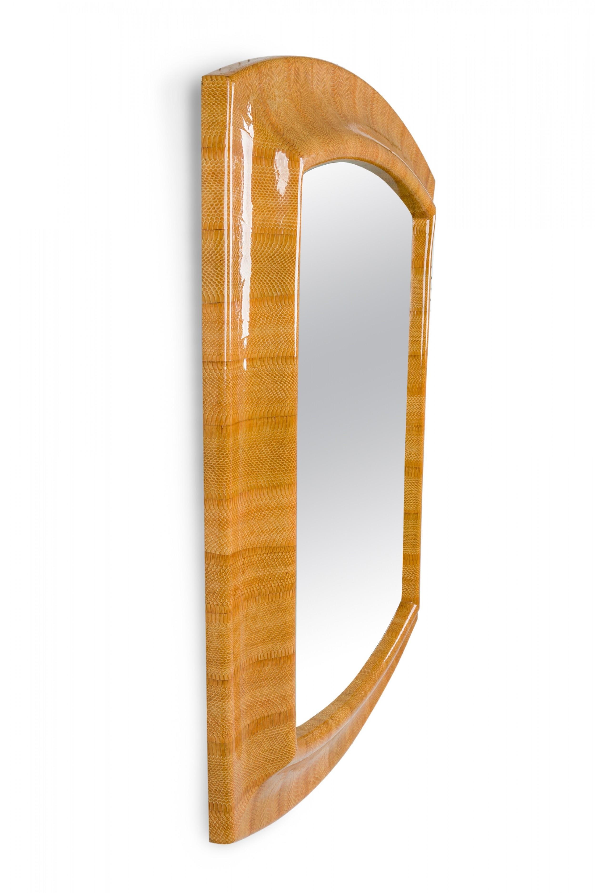 Miroir mural américain du milieu du siècle, de forme rectangulaire avec le haut et le bas incurvés, encadré dans un cadre en placage de peau de serpent marron clair. (KARL SPRINGER)

Condit : Bon ; Usures dues à l'âge et à l'utilisation