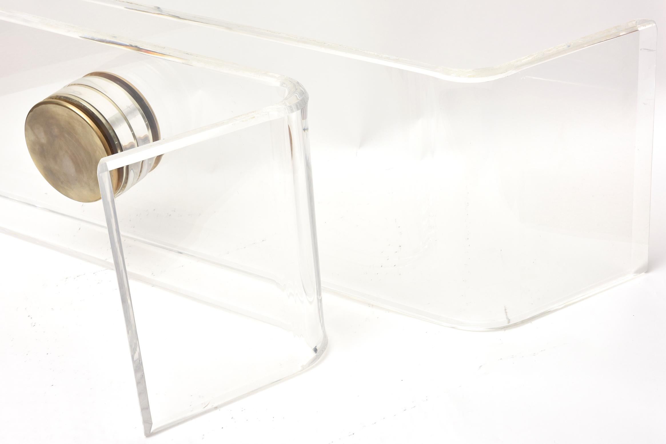 This wonderful angled and sculptural Karl Springer lucite table base has brass caps.There is no glass provided for this great base. One piece of lucite is longer than the other as it curves outward. The brass caps on either side are 6.25