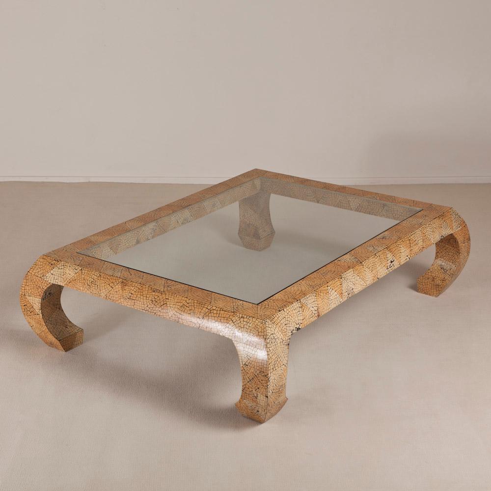 Coconut shell veneered coffee table with curved legs and an inset glass top. The shell has been placed to create a triangular frieze around the whole table. 1970s-1980s.

Karl Springer established a tiny workshop in Manhattan and started