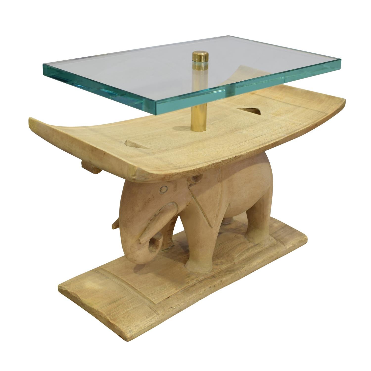 Authentic hand carved African elephant table with customized glass top and polished brass fittings by Karl Springer, American 1980s.  These Karl Springer African tables are rare gems.

Karl Springer incorporated authentic African artifacts into his