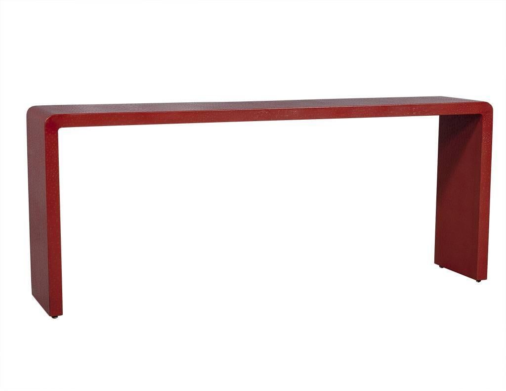 This modern console table is designed by Karl Springer. Composed of red ostrich leather, it is crafted into a u-shape and curved at each end. A unique piece perfect for a bright and cheery home.