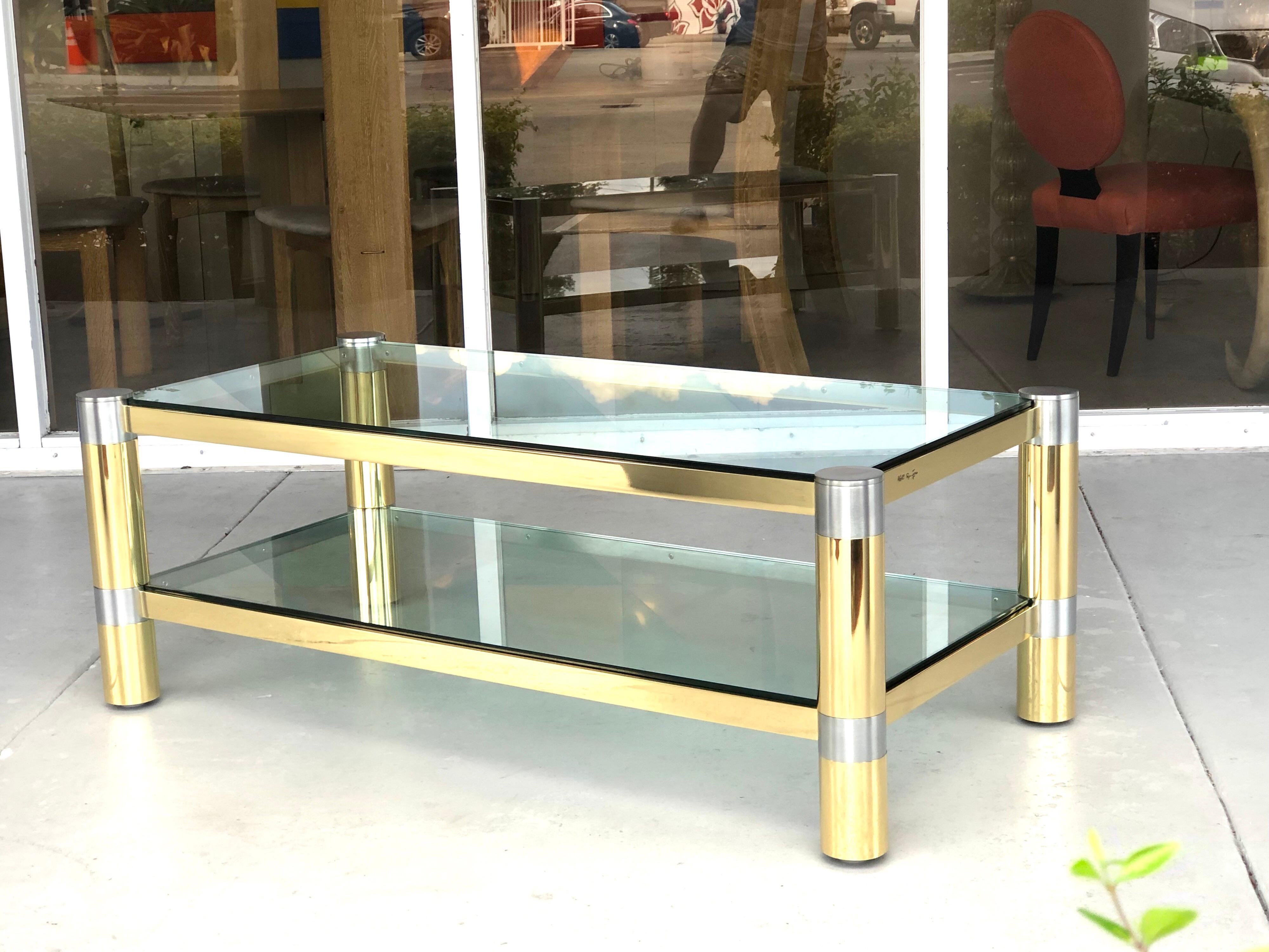 A polished brass and brushed steel coffee table by Karl Springer. The table is a double decker, with 2 thick glass tops.