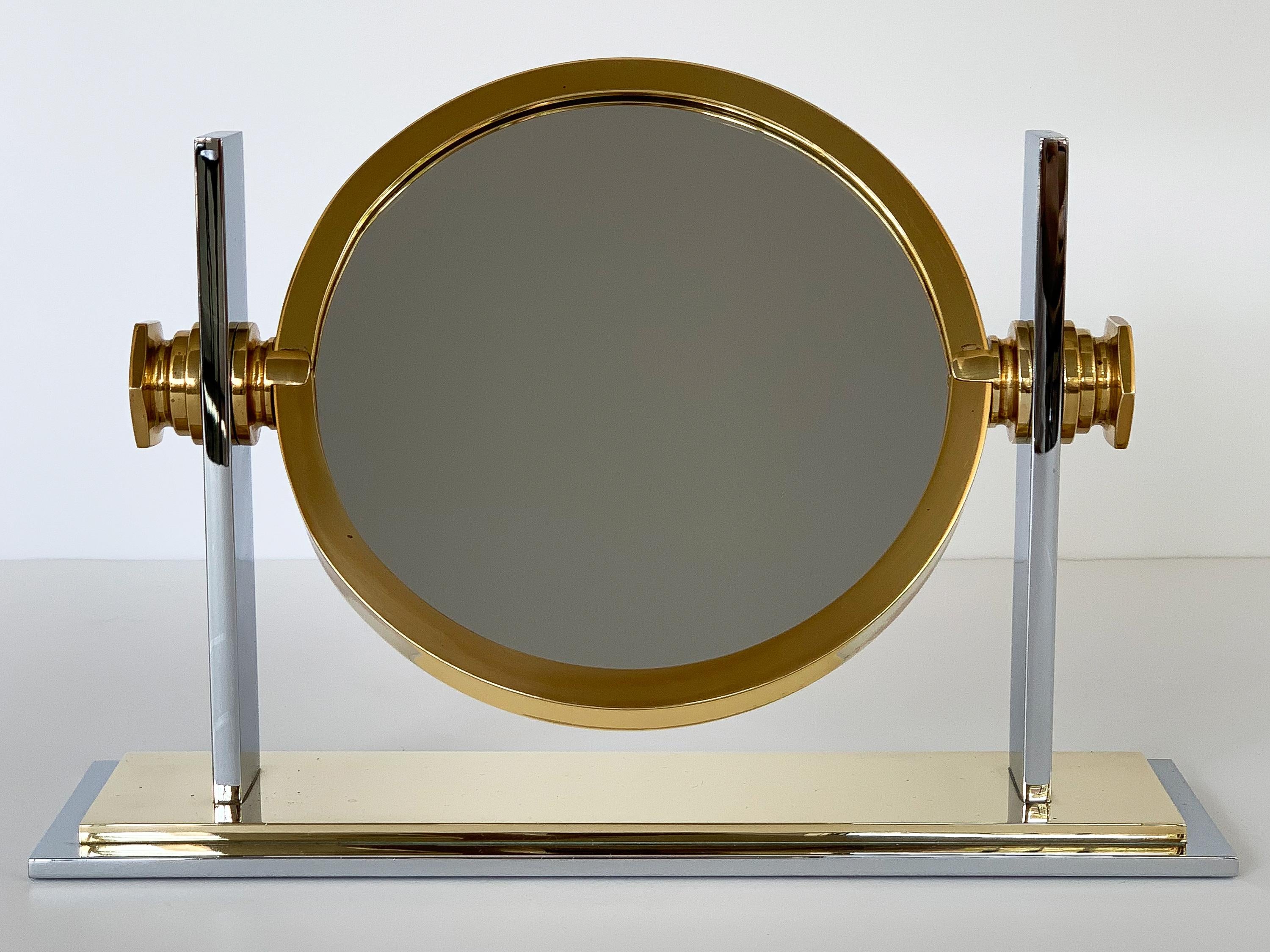 A brass and polished nickel tabletop vanity mirror designed by Karl Springer, circa 1980s. Smaller scale model with an 8.5 inch brass framed round mirror. The mirror is a adjustable. The mirror can be tilted and rotated for choice of mirror. One
