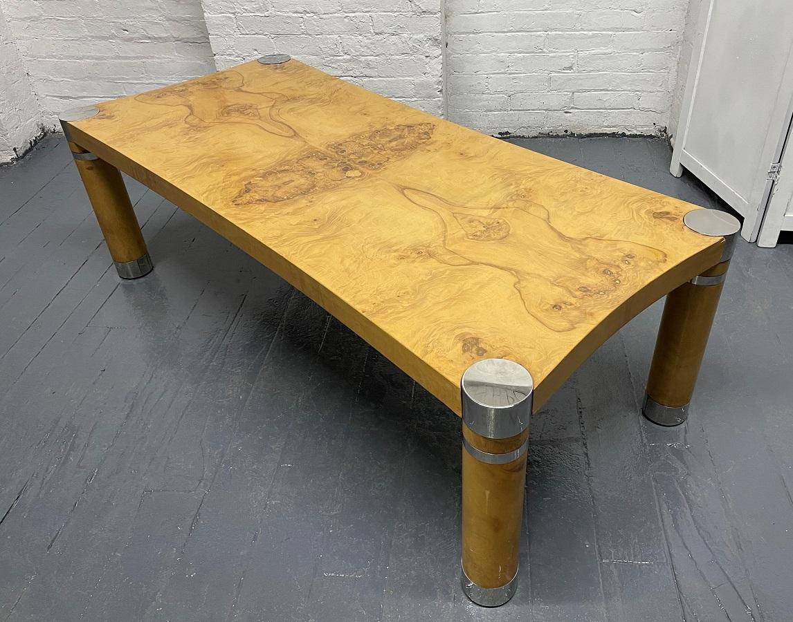 Karl Springer burl olivewood coffee table. The table has cylindrical shaped legs with polished chrome mounts.
