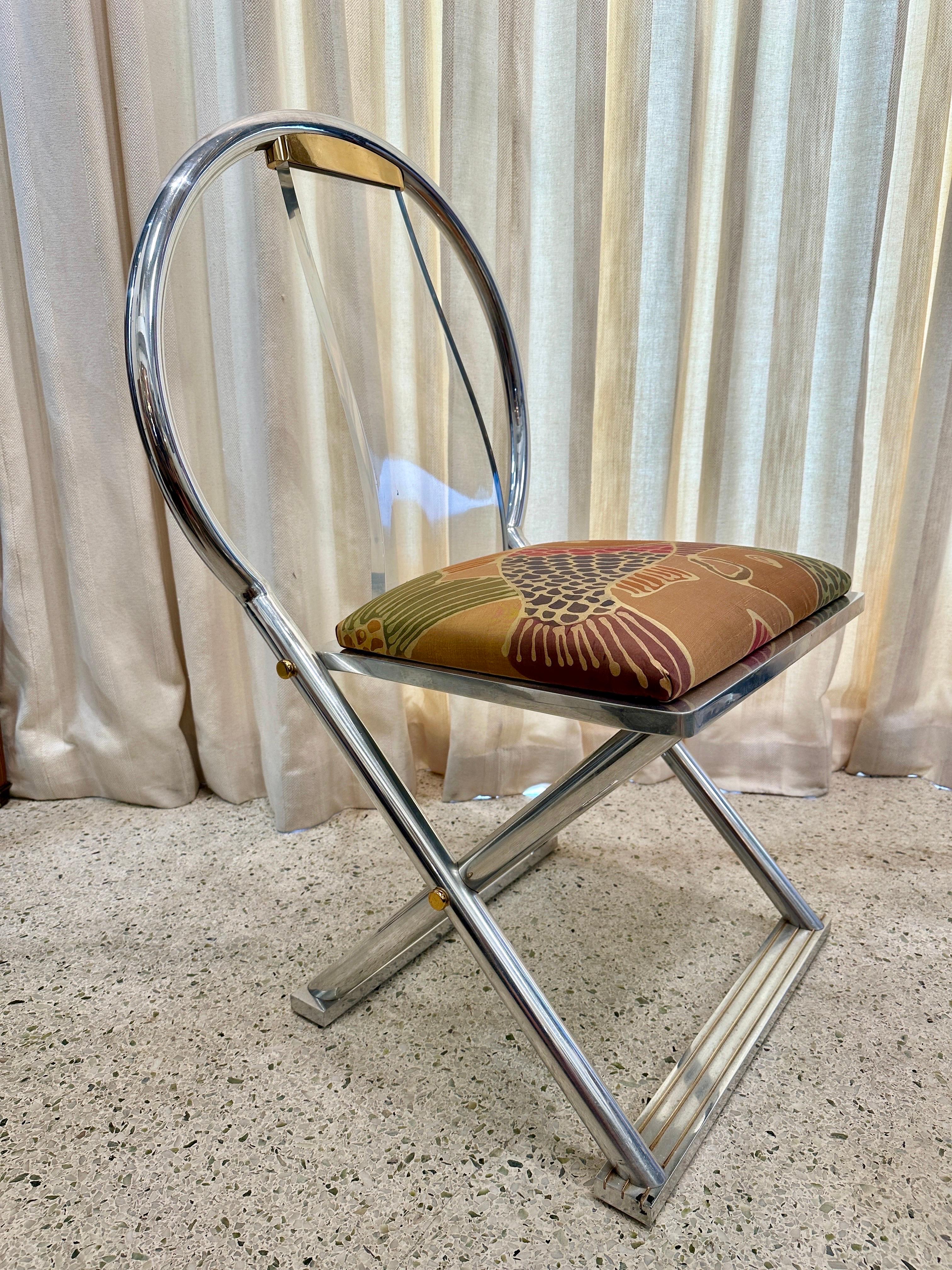 Cette chaise rare documentée de Karl Springer, trouvée dans son catalogue de créations originales, est faite d'acier chromé, de laiton et de lucite. Le coussin d'assise est recouvert d'une fine soie avec une scène de koi vibrante.