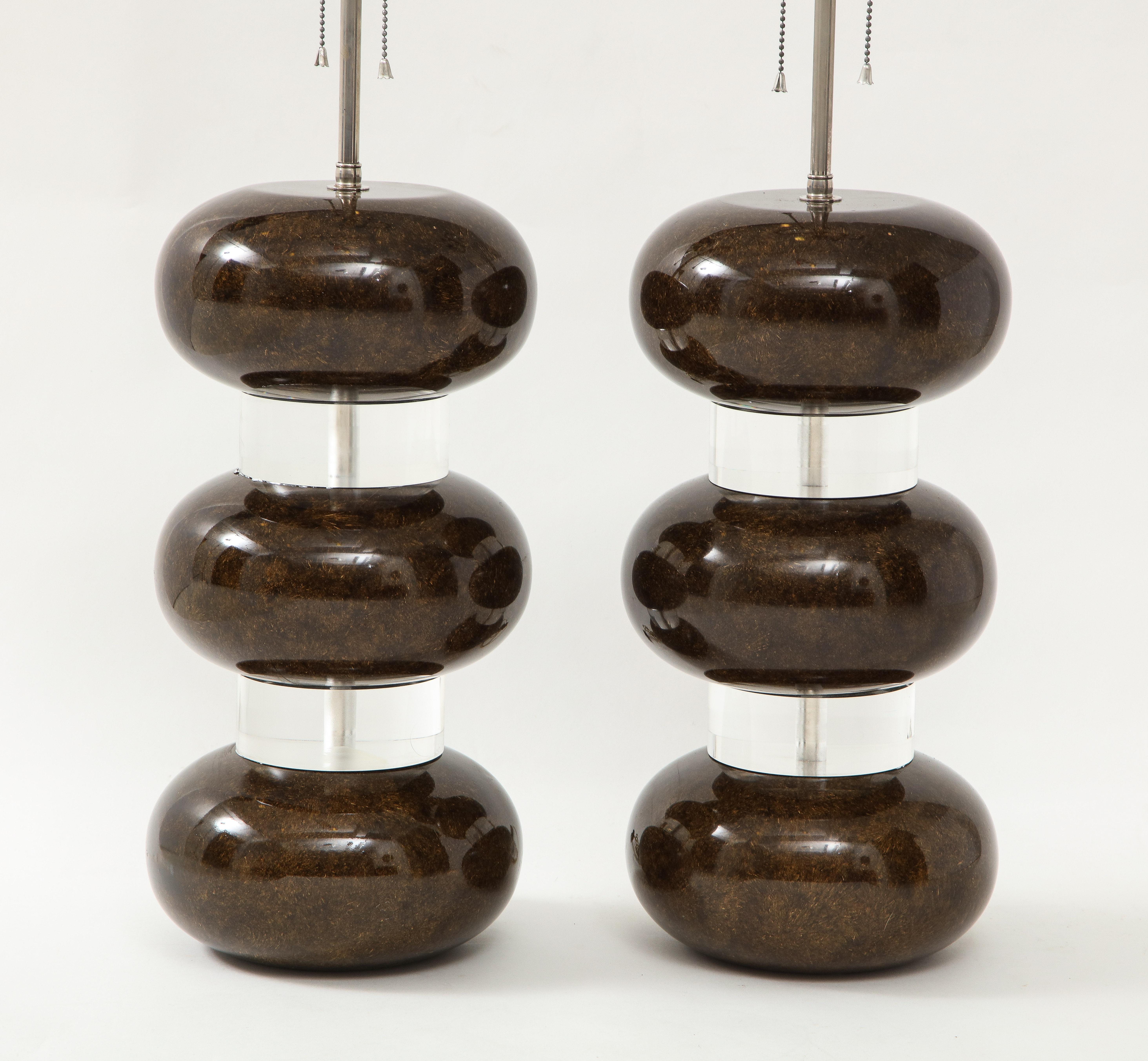 A wonderful rare pair of Karl Springer clear and cased brown Lucite bubble lamps. A central stem in chrome hold two-light sockets.