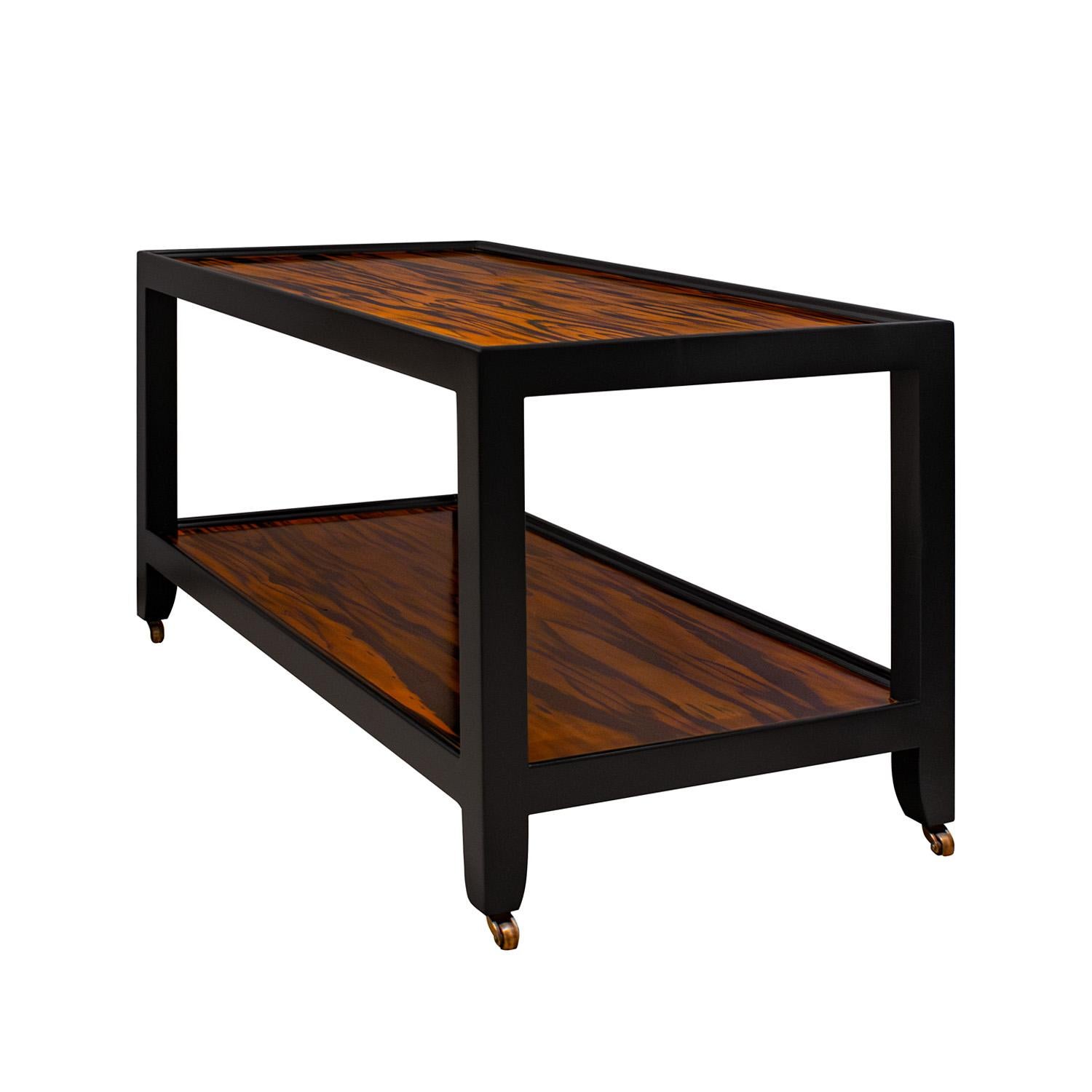 Striking Telephone Style Coffee Table in beautifully figured zebrawood with frame in black lacquer and with brass castors by Karl Springer, American 1980's. The figured zebrawood is very luxurious. Like all Karl Springer pieces, this coffee table is