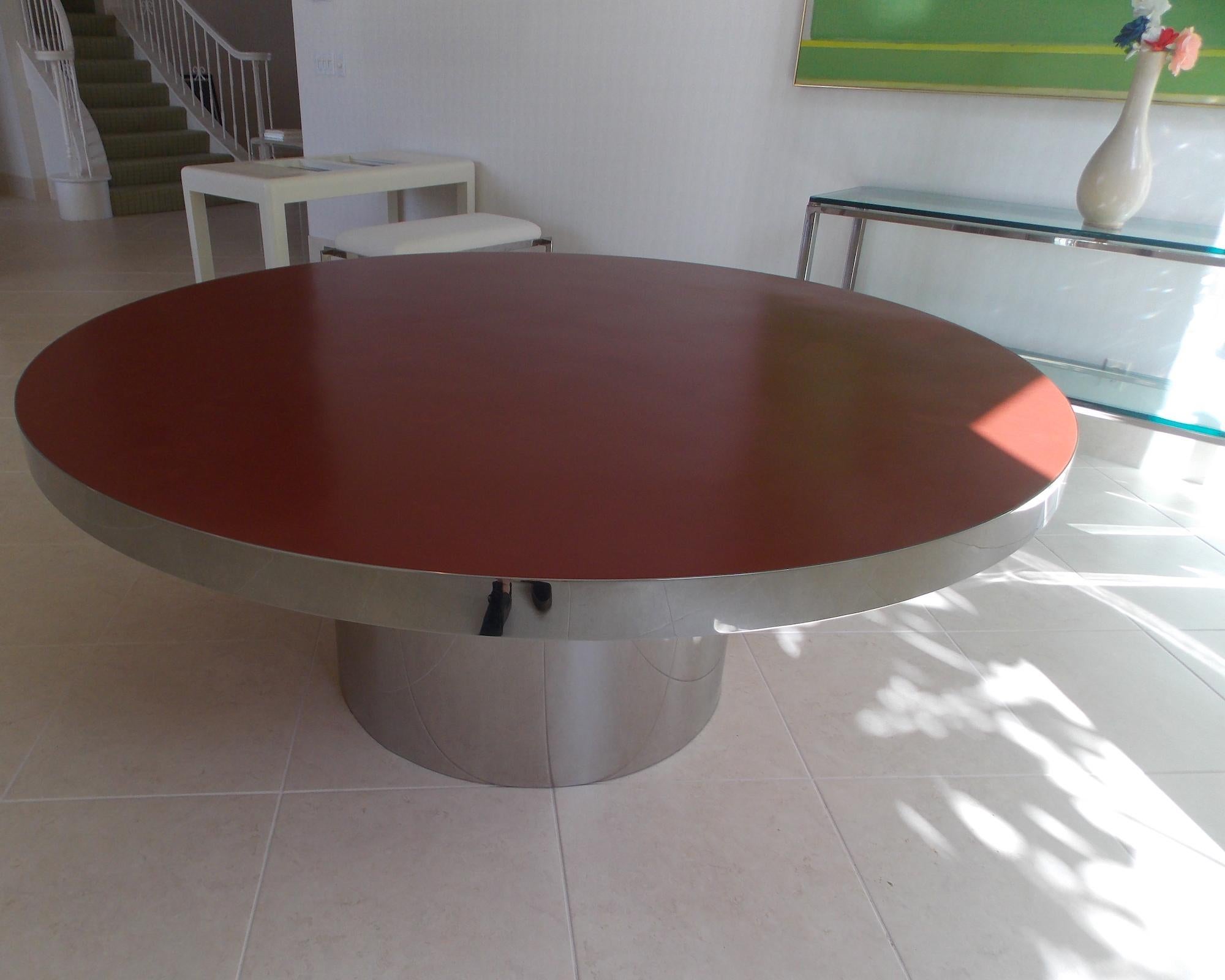 Karl Springer round custom dining table.
Polished Stainless Steel with a Oxblood Red Glasurite Top.
Glasurite is a Stone compound developed by Karl Springer.
Authenticated by Tom Langevin.