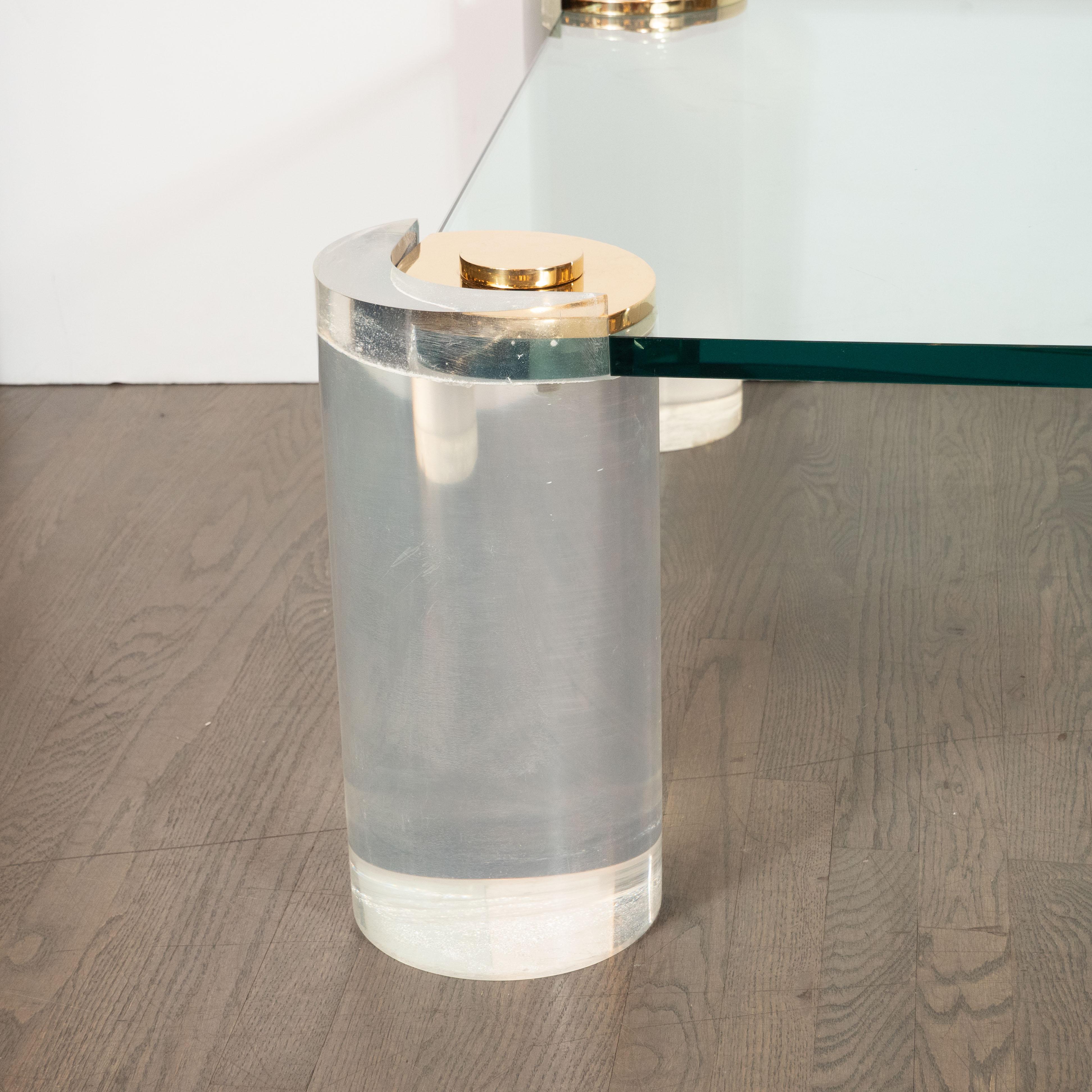 This sophisticated cocktail table was realized by Karl Springer- one of the most important and influential designers of the 20th century, circa 1985. It features cylindrical Lucite legs that attach to a rectangular glass top with rounded corners via