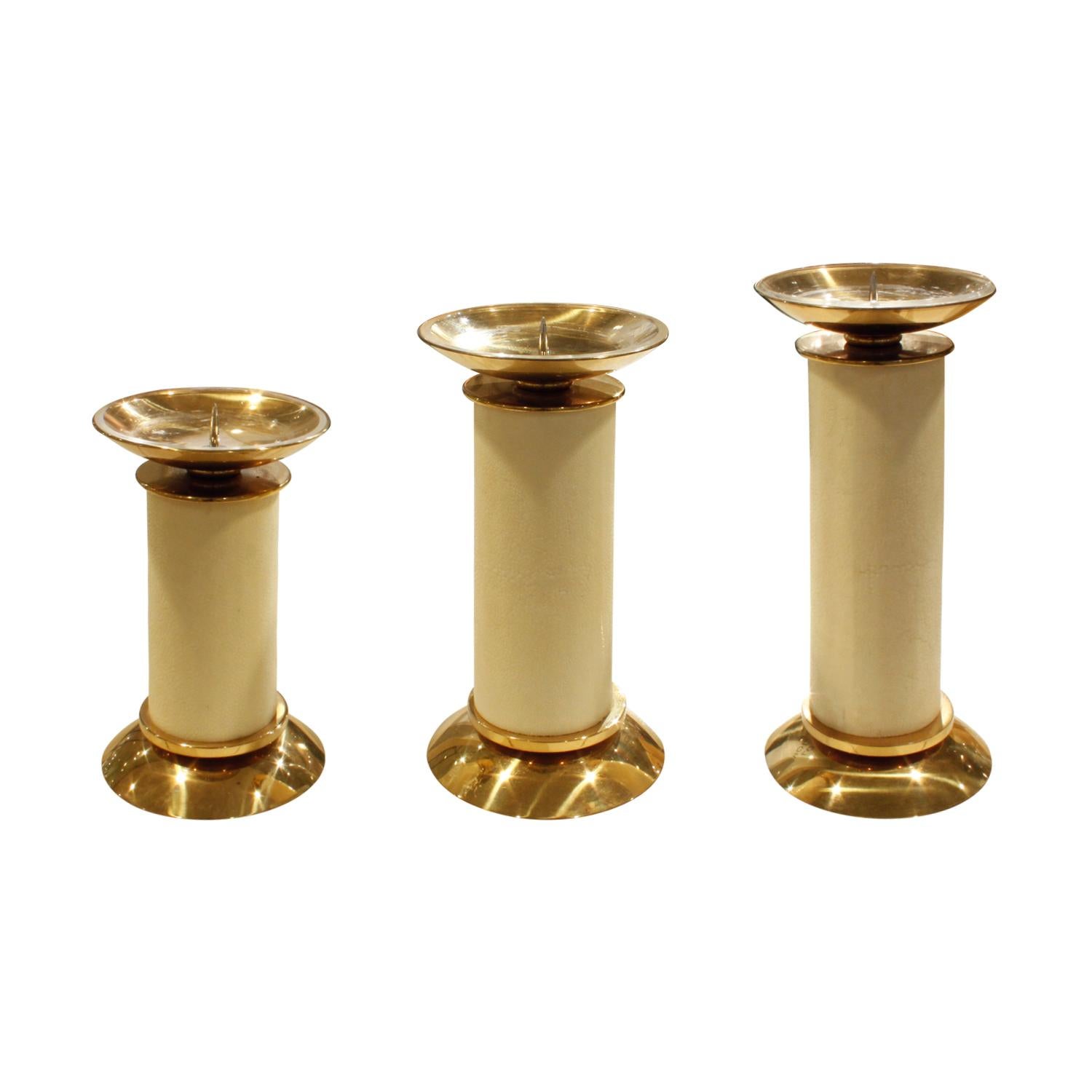 Exceptional set of 3 candle holders in brass and ivory shagreen with Lucite bobeches by Karl Springer, American, 1980s. 

Dimensions for each:

Measures: Diameter 4.5 inches
Height small 7.5 inches / with candle 13.5 inches
Height medium 9