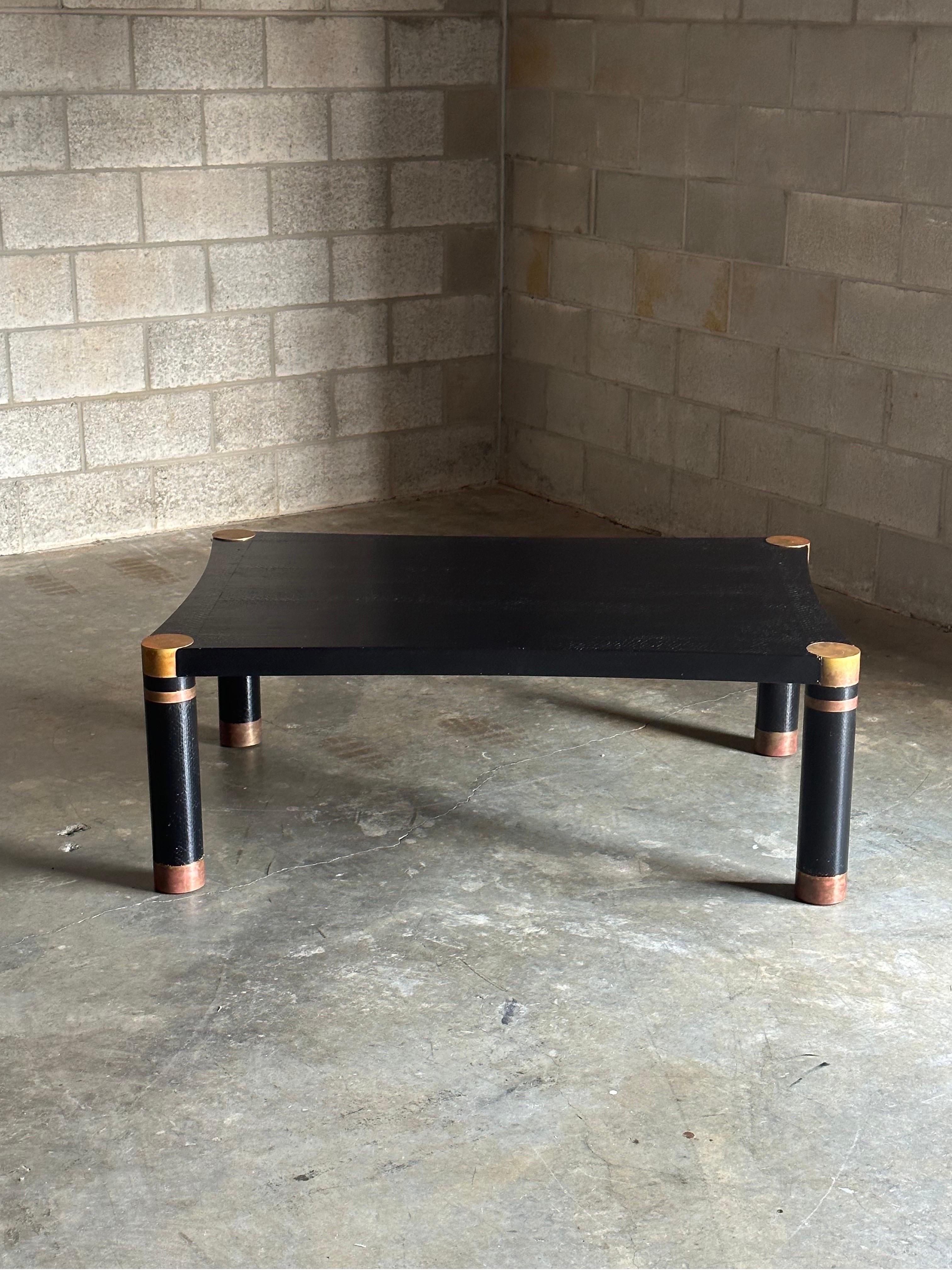 Karl Springer coffee table in what appears to be sea snake leather with Patinated brass accents. Lovely simplistic form with nods of elegance through the reversed arched sides. Brass details show fantastic patina. A wonderful example from one of the