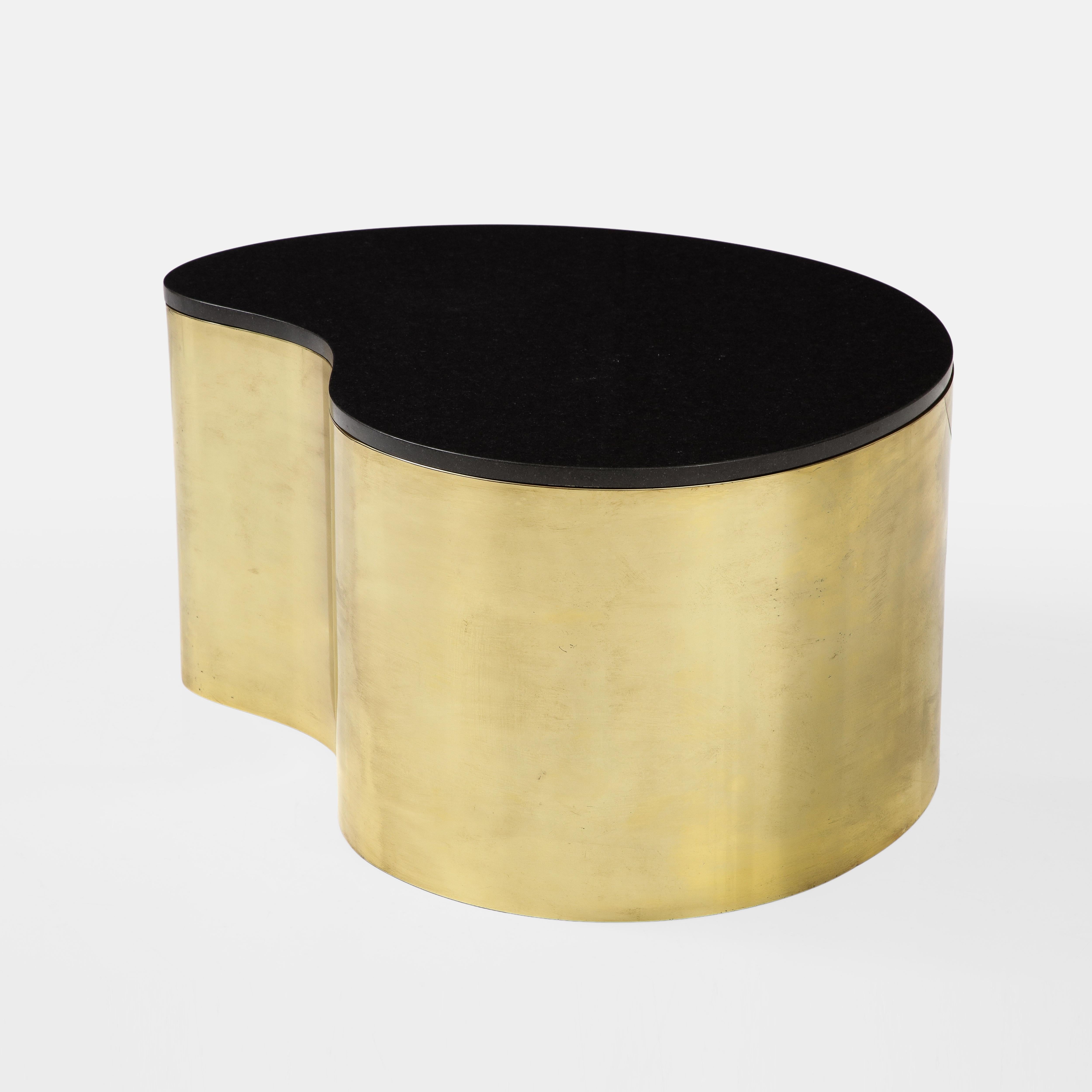 Karl Springer for Karl Springer LTD exceptional free-form coffee table with polished brass base and black granite top, designed circa 1970. This iconic Springer low table design has a unique amorphic shape with a seamlessly welded strip of brass