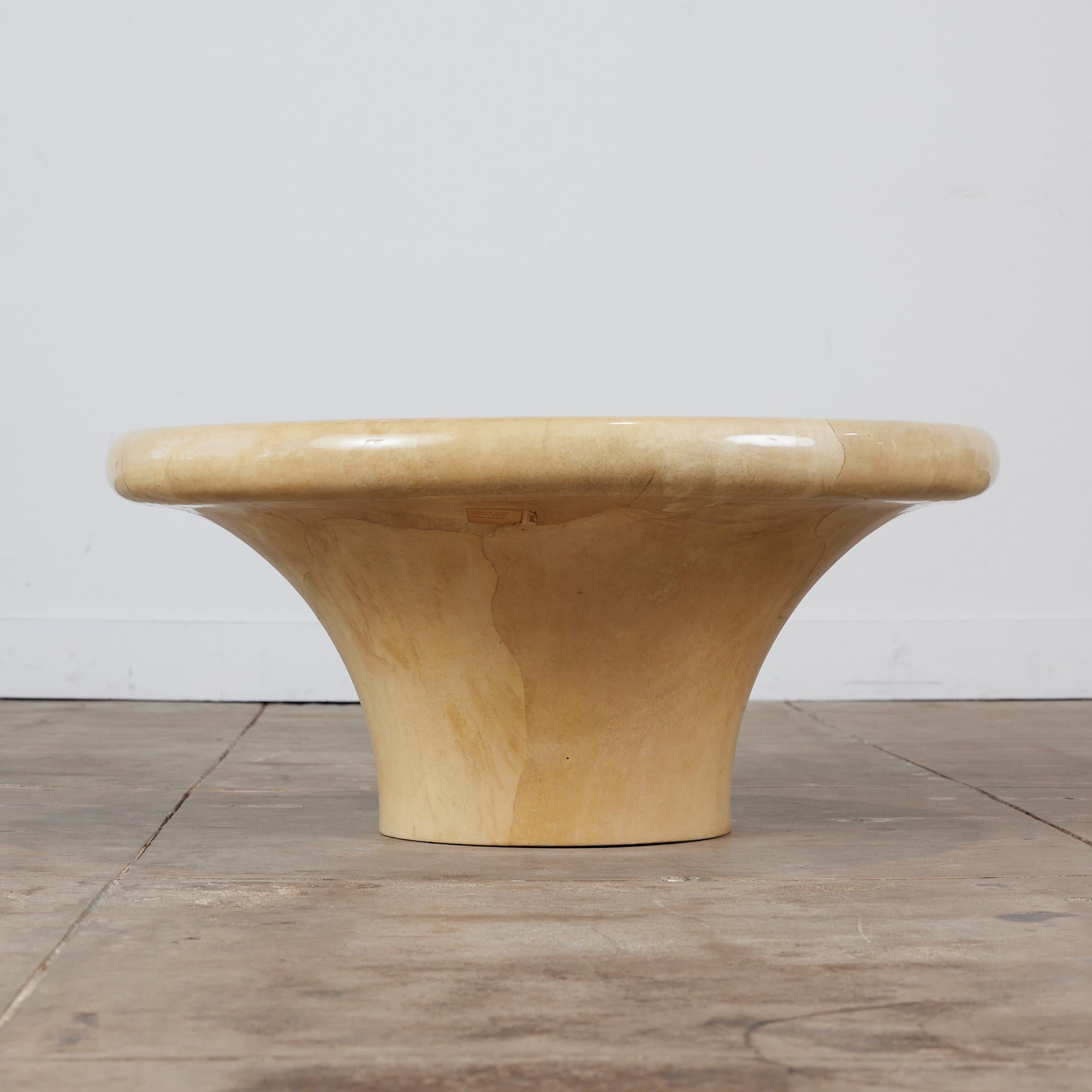 A postmodern mushroom coffee table by Karl Springer, c.1980s, USA. This coffee table features a lacquered goatskin with a smooth finish and soft rounded edges. The pedestal table is a natural beige color throughout.

Dimensions: 36