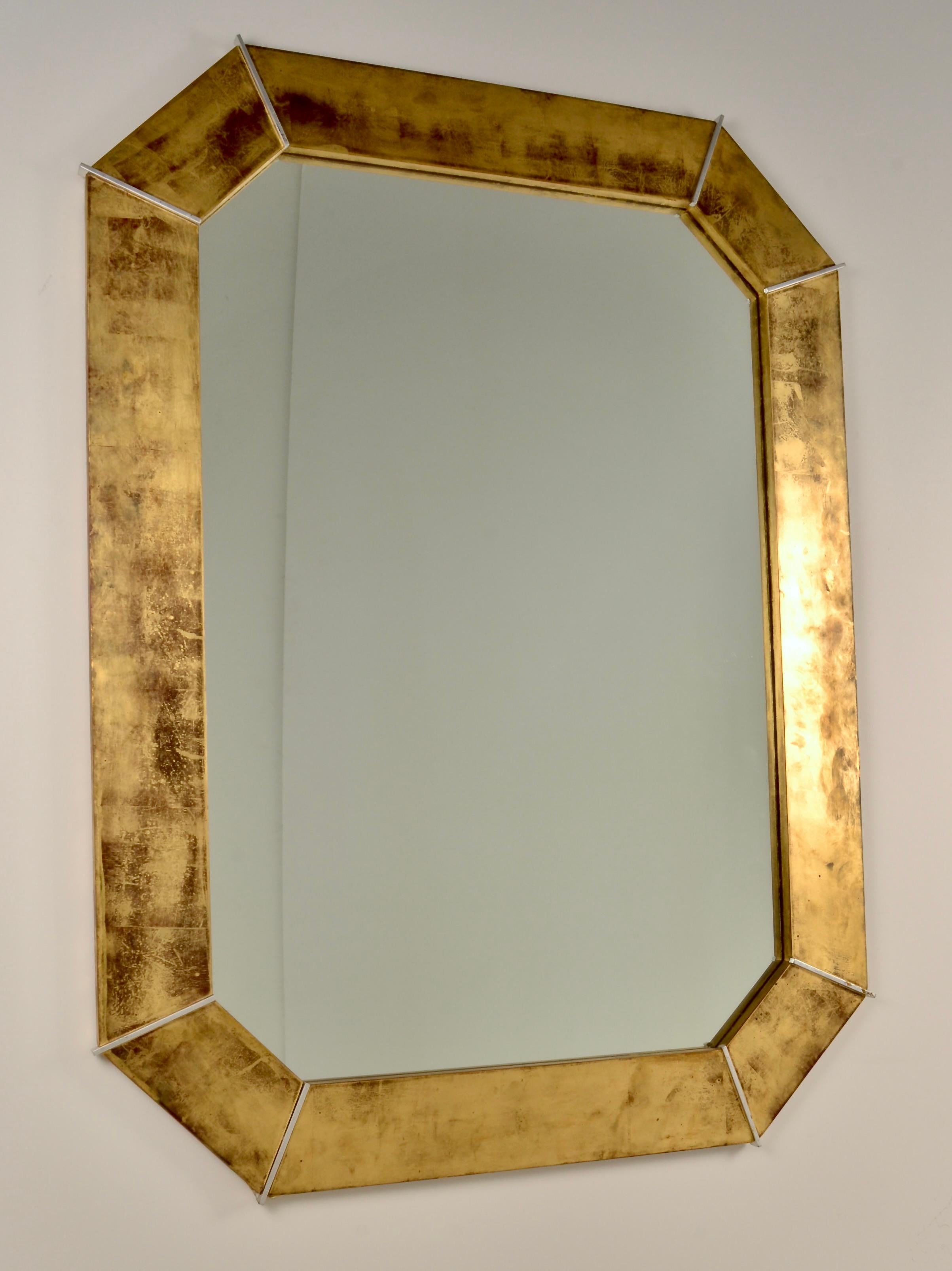 This large scale octagonal mirror by designer Karl Springer features a dramatic custom distressed gold leaf finish over wood, detailed with silver gilt dividers. Crafted with Springer's famously high quality. In very fine condition. 