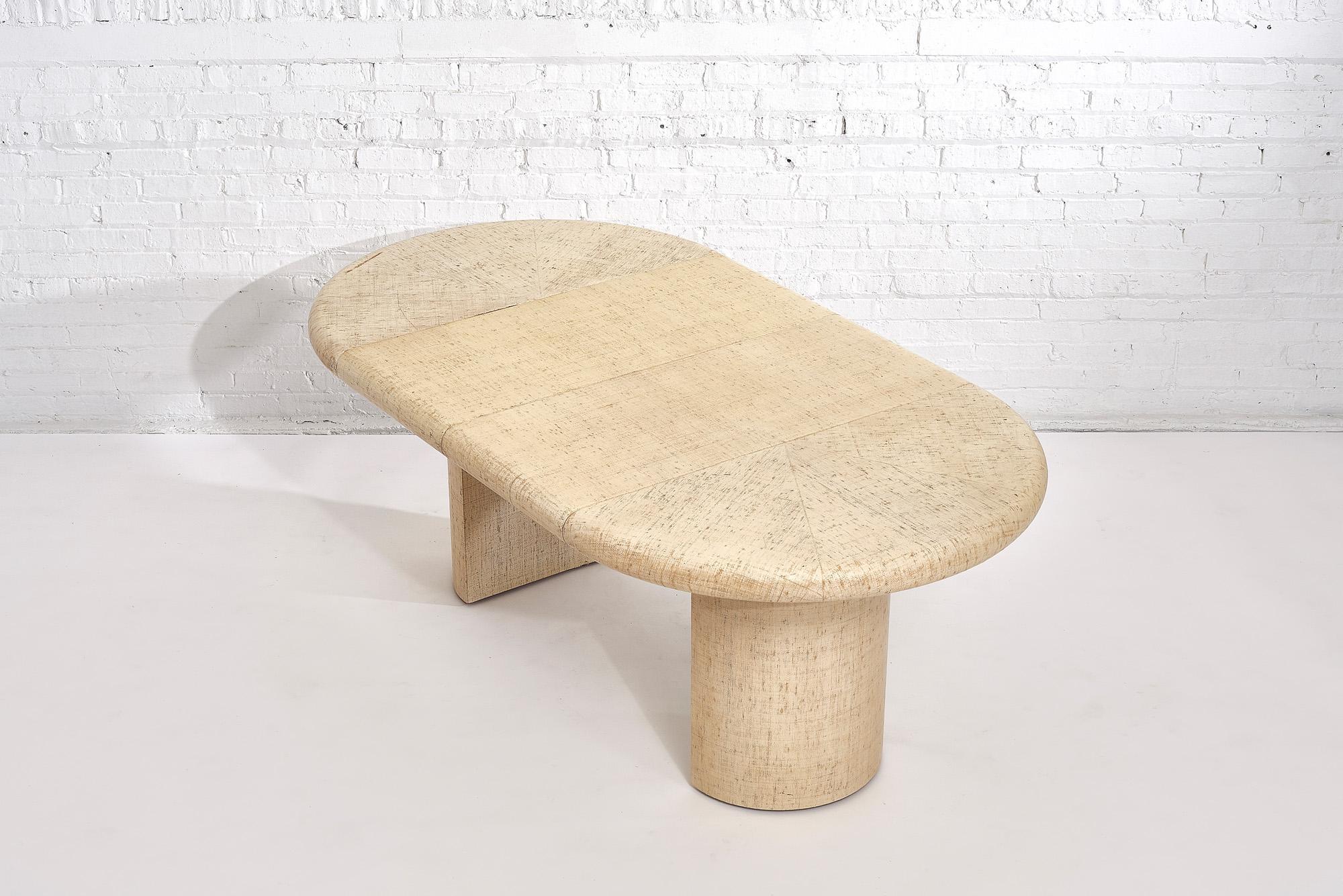 Early Karl Springer natural/ivory lacquered grasscloth dining table with thick bullnose edge, circa 1970. Round table that has a double pedestal base that splits when expanded to use leaves.