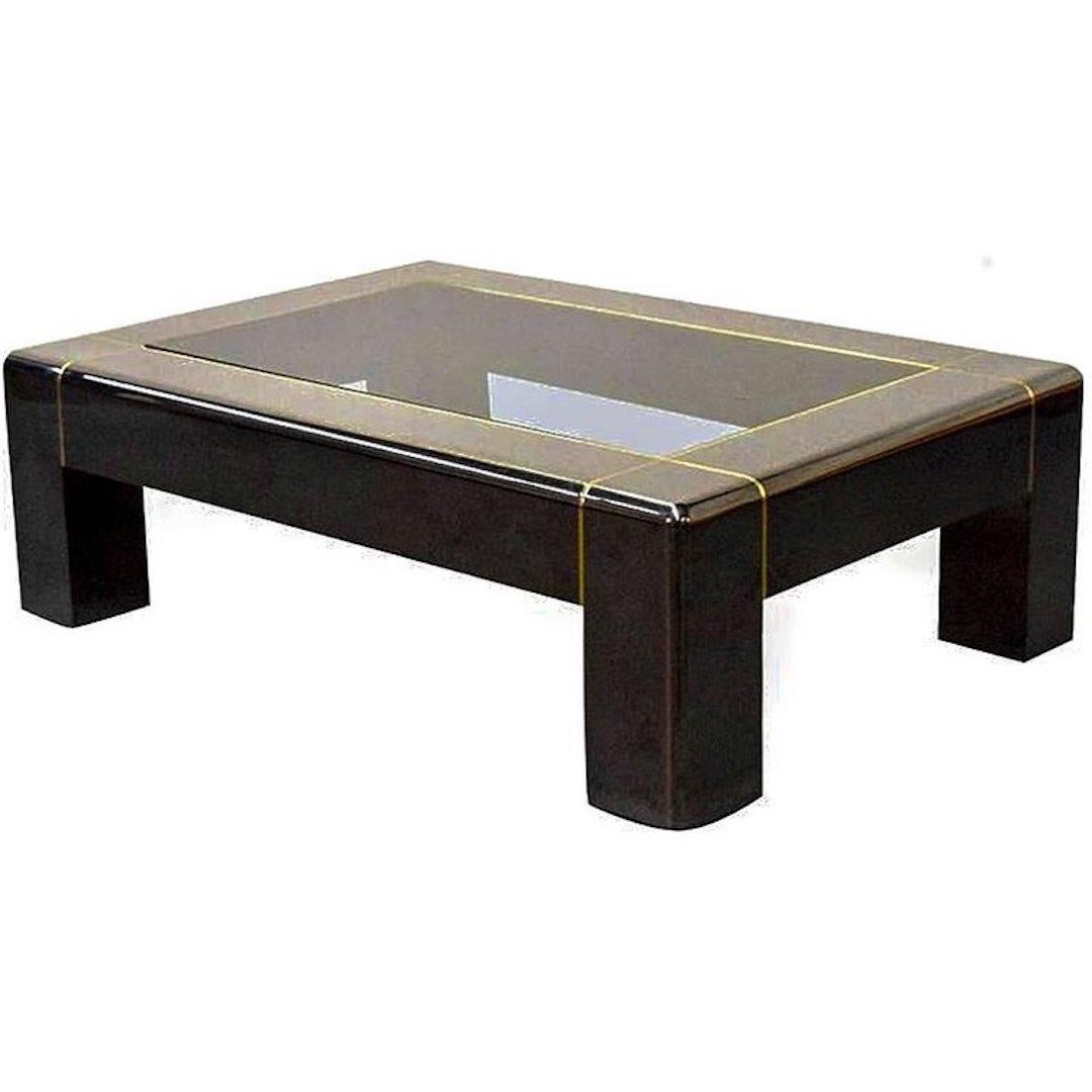 Exceptional, iconic Parsons style coffee table in heavy gunmetal with a smoked glass inset top and brass pinstripe inlay. Pictured in the Karl Springer catalog. In overall great condition, with a few minor wear areas.
