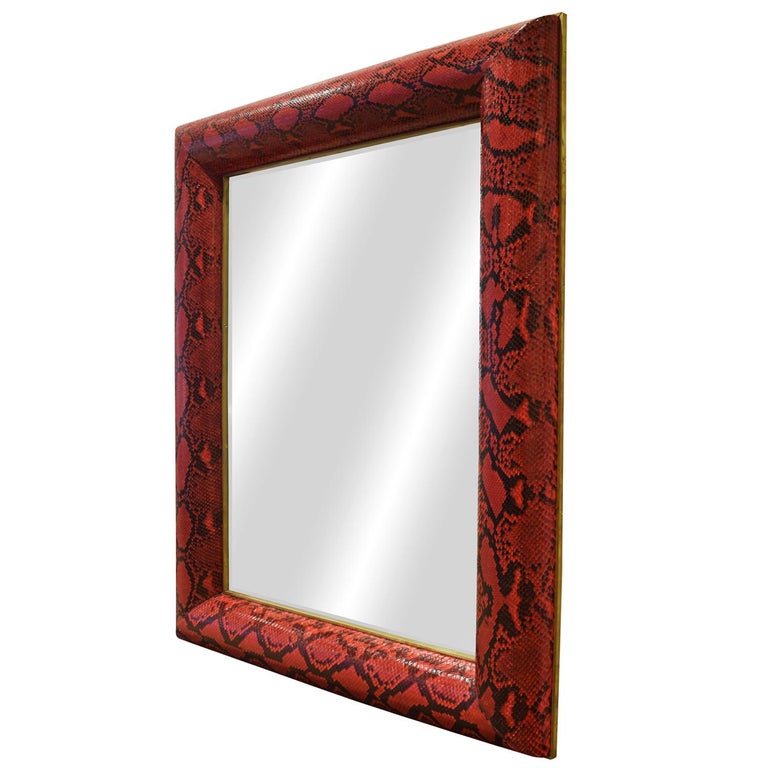 Exquisite “Half Round Molding Mirror” covered in red python skin with brass trim along inside and outside edges of frame with beveled mirror by Karl Springer 1980’s (Signed on back with brass “Karl Springer” tag). This mirror is a tour de force of
