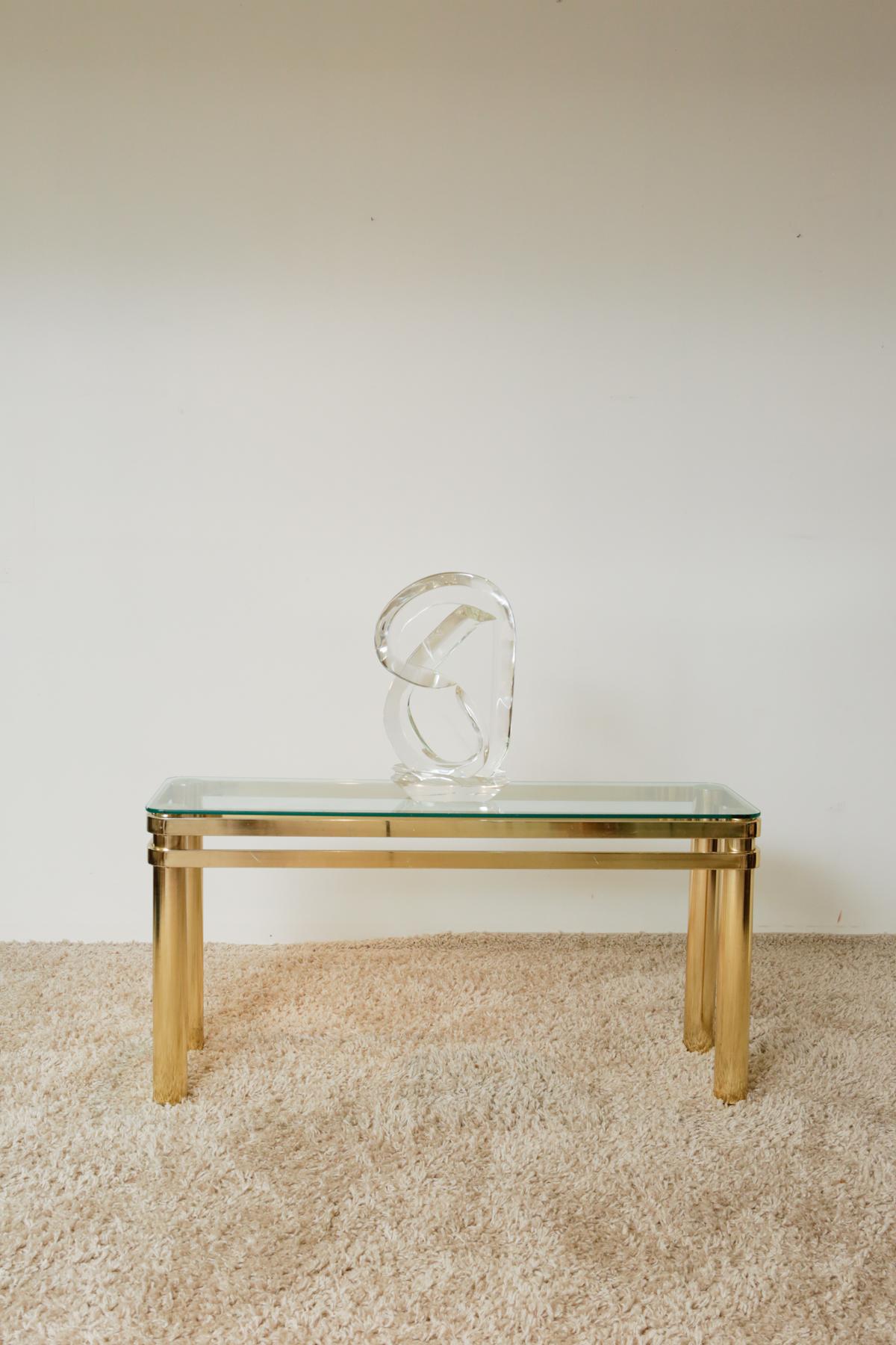 Karl Springer Hollywood Regency style brass and glass console table

Vintage Karl Springer-style brass console table with a glass top, Circa 1970s. Stunning design with curved edges on the glass top. Its simple lines consist of four brass tube