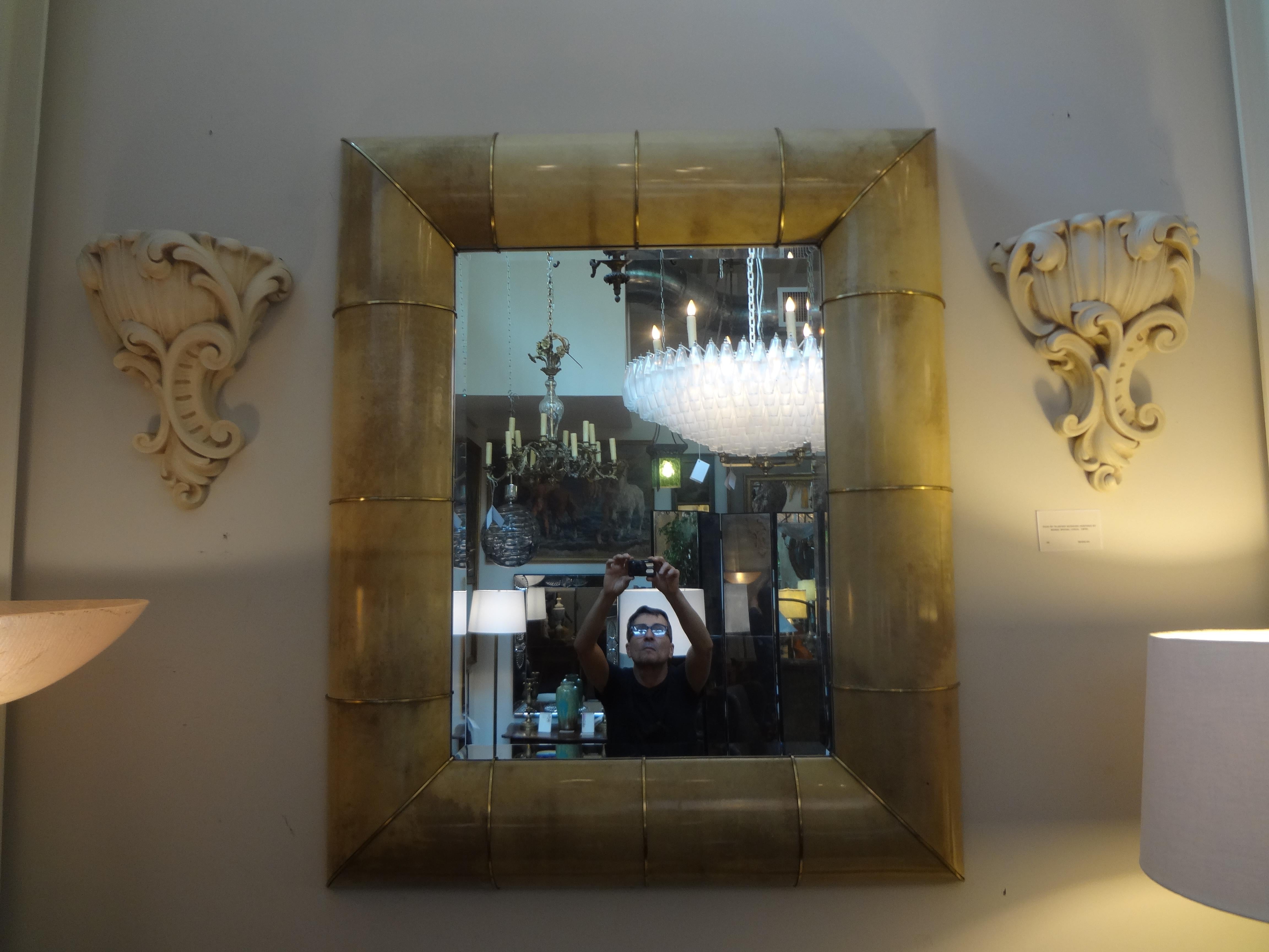 Stunning large rectangular goatskin and brass beveled mirror. This cream colored Mid-Century Modern goatskin and brass mirror can be hung vertically or horizontally.