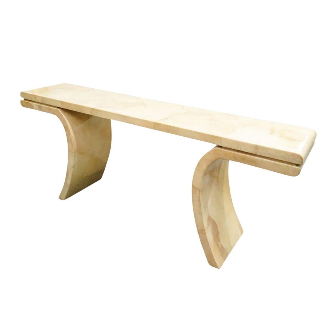 The Karl Springer Inspired Goatskin Console Table With Flared Legs is a striking piece crafted from lacquered goatskin, designed to resemble the look of marble. Featuring a solid altar form and flared legs, it brings a bold, sophisticated touch to