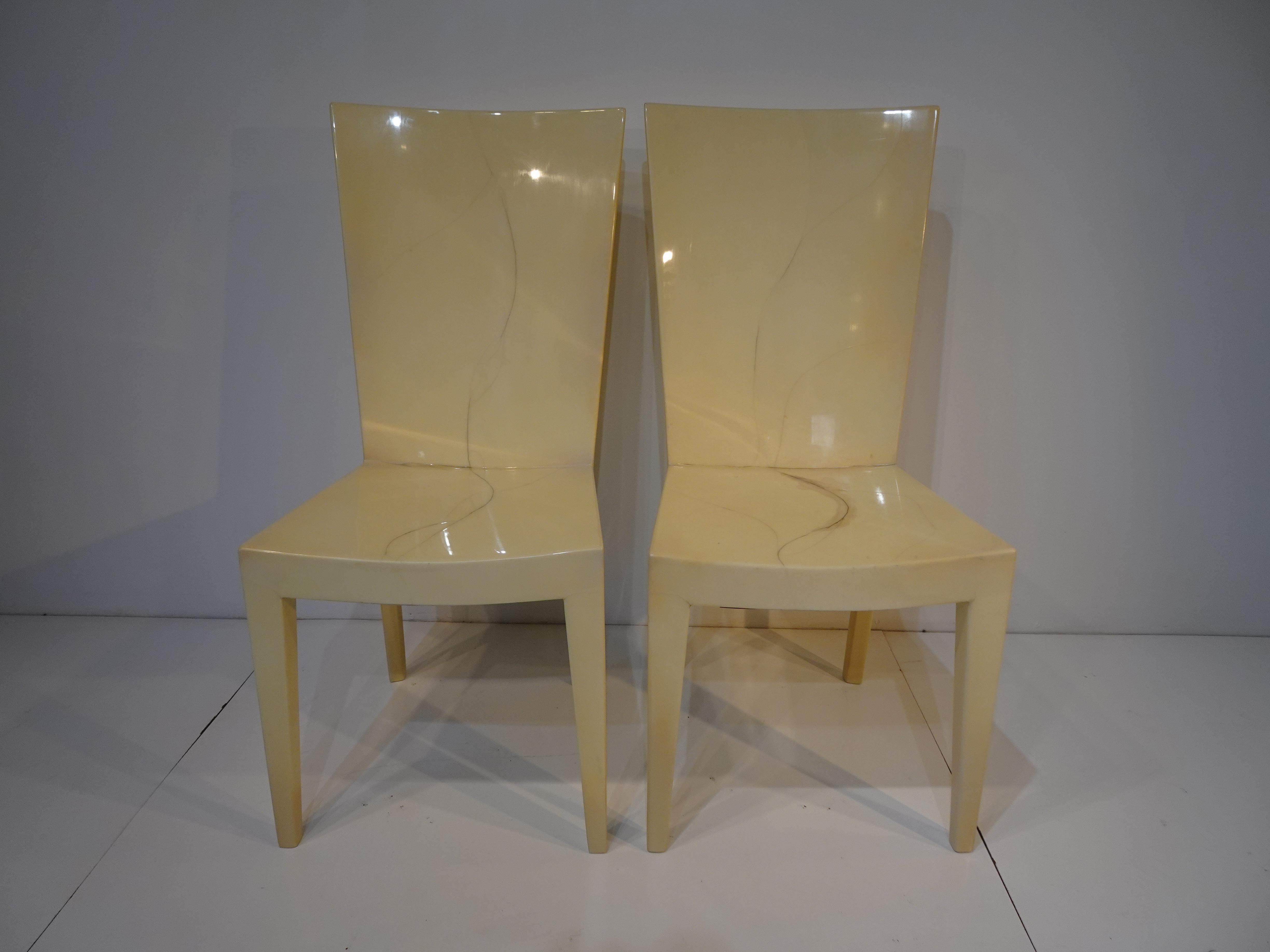 A pair of tall back goatskin covered chairs with a high toned lacquered finish having a simple sophisticated elegant look . Produced in the 1970's this chair has stood the design test of time and can be used as head chairs in a dining set or as side
