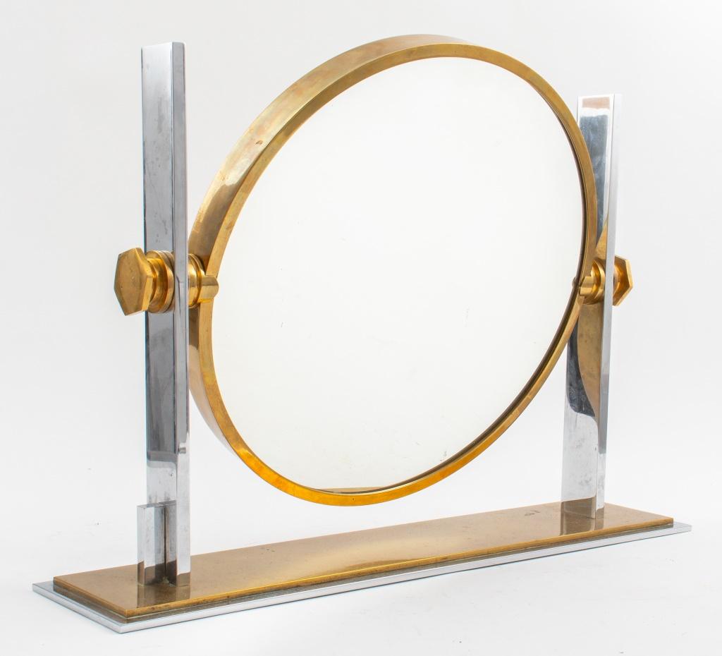 Karl Springer (German-American, 1931 - 1991) Modern chromed metal and gold-tone brass reversible vanity mirror with one magnified mirrored glass side, circa 1970s. 19.25
