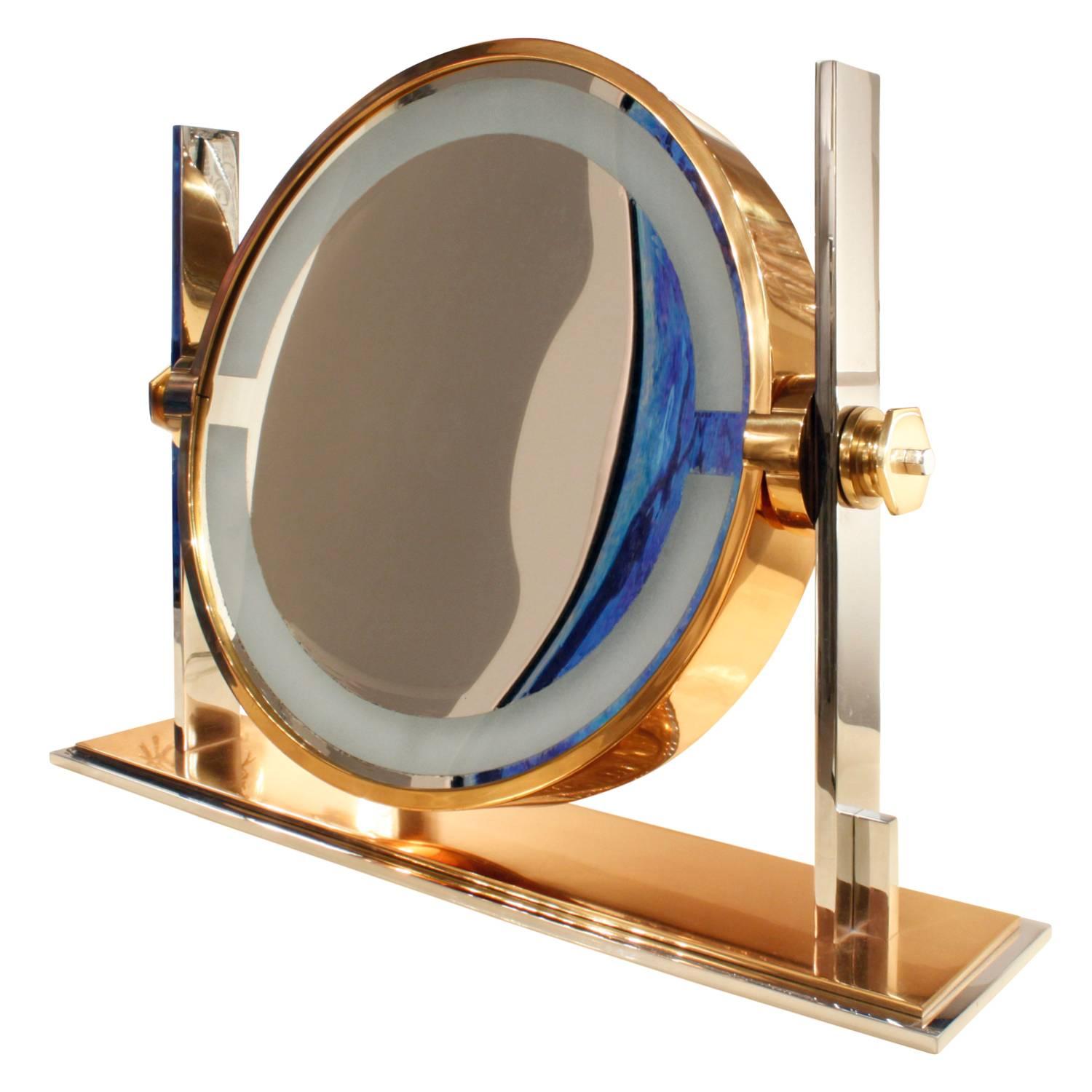 Exceptional and meticulously crafted illuminating vanity mirror in polished steel and gold lacquered brass with magnifier by Karl Springer, American, 1980s. This large vanity mirror is very impressive.