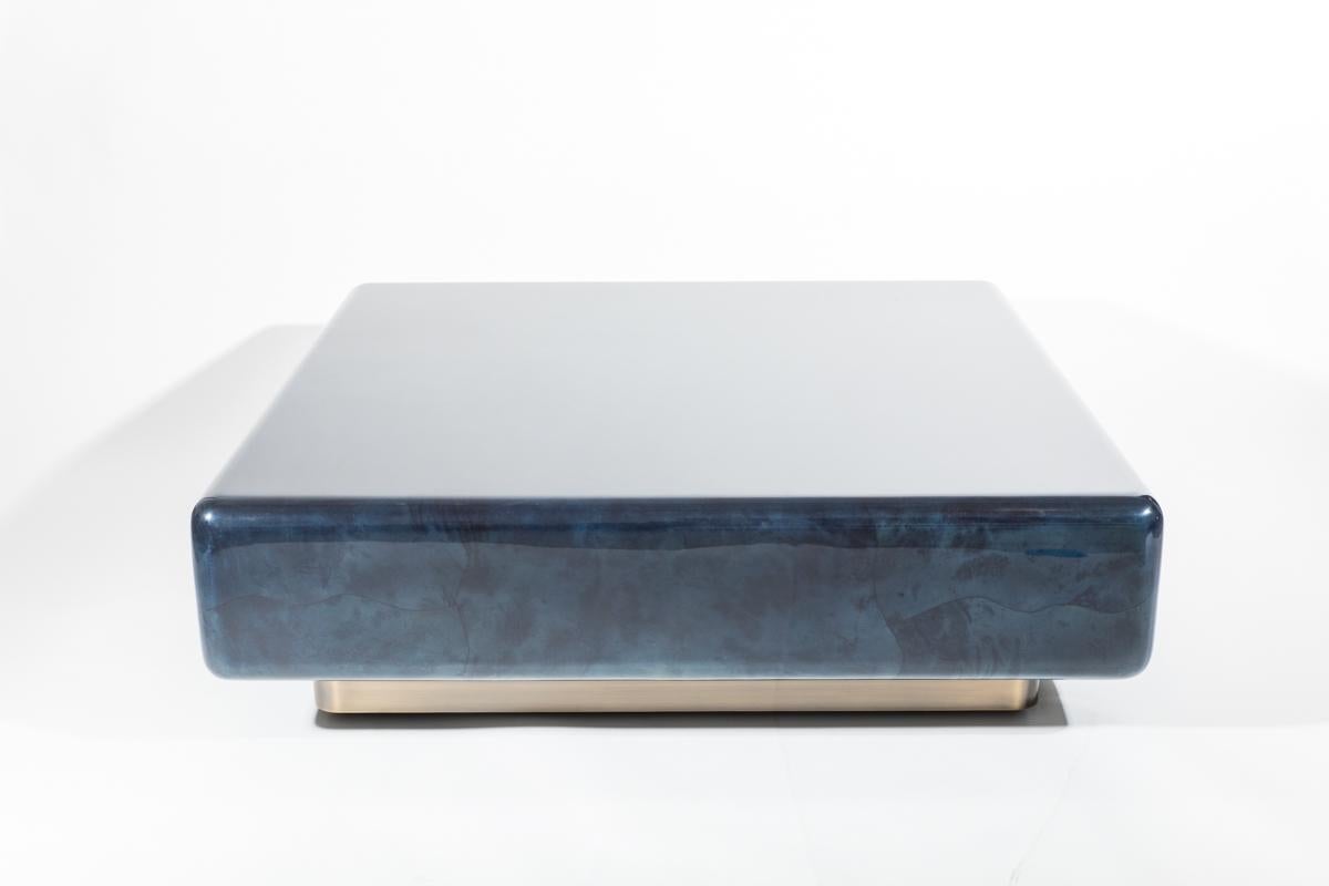 This over-scaled low table is made with freeform inlay of natural goatskin with a polished lacquered finish. Springer‘s minimal form highlights the luxury of his materials. The marble-like table sits on a square bronze base creating floating effect.