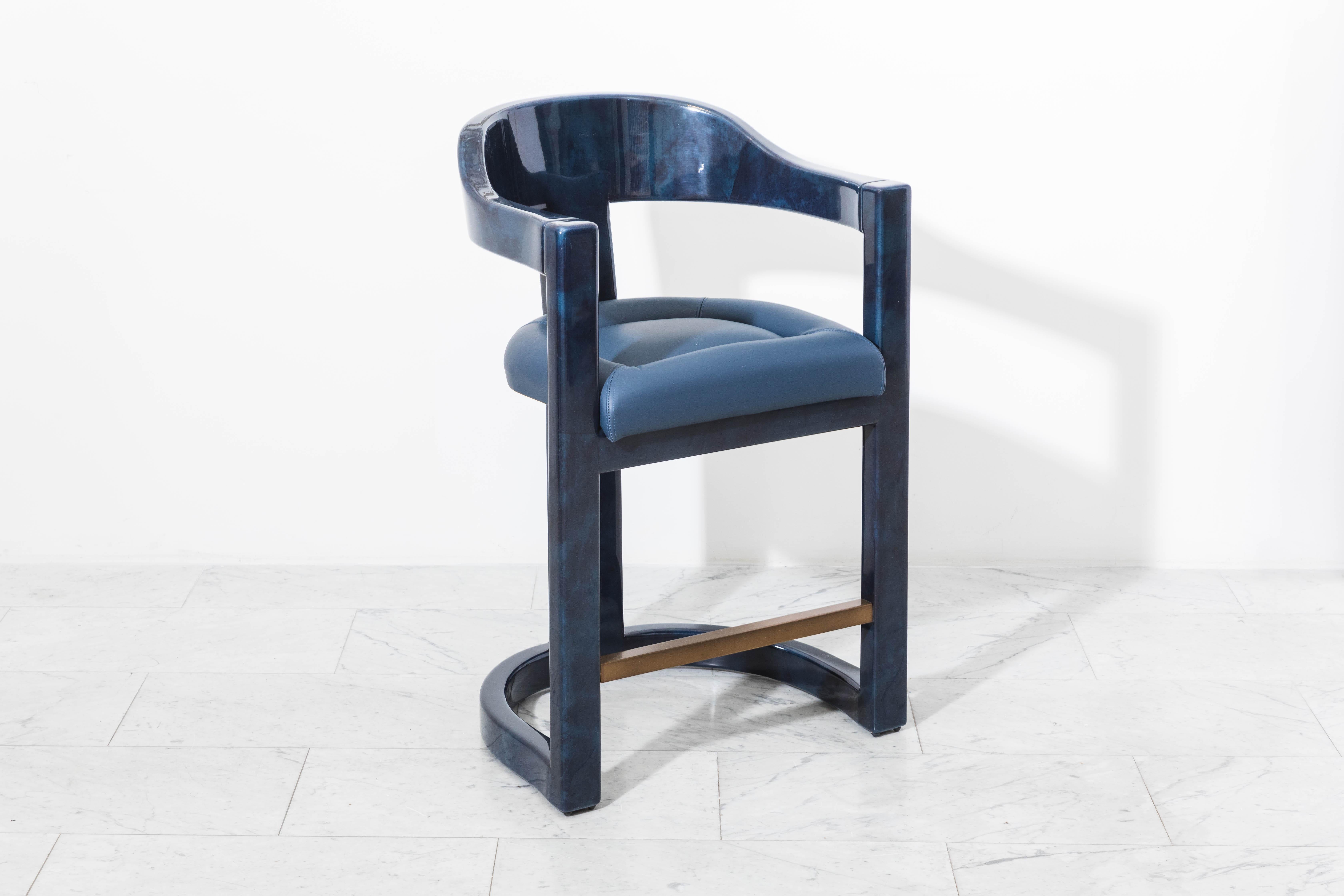 An iconic form by Karl Springer, the Onassis barstools are now available through Karl Springer LTD exclusively at Todd Merrill Studio. The stools feature a barrel back with semi circular arm rests that embraces the body and a bronze footrest. The