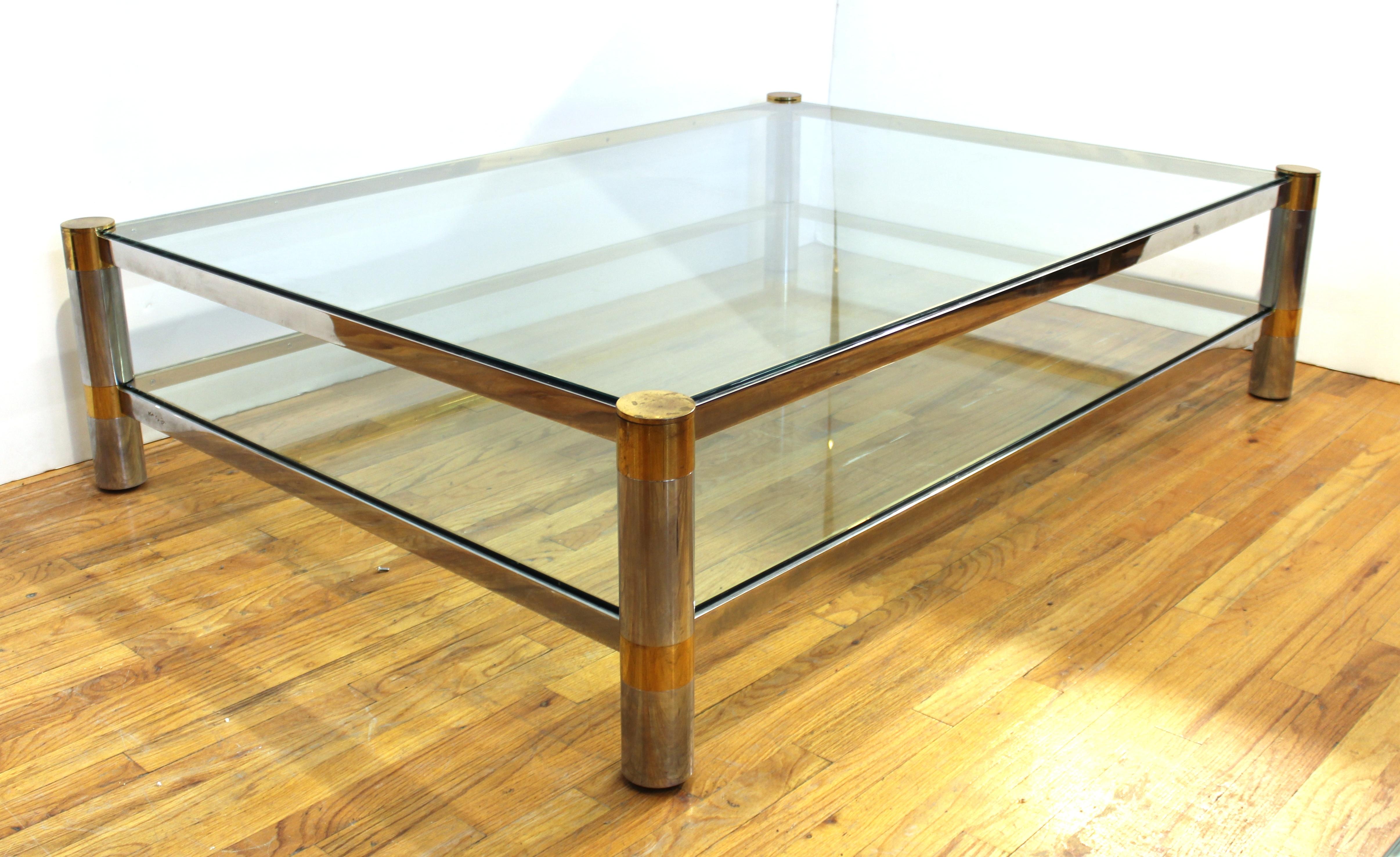 American Modern cocktail or coffee table of monumental proportions, designed by Karl Springer in the 1970s. The piece has a nickel and brass structure and two heavy glass tiers. Signed 'Karl Springer' on one of the sides. In great vintage condition