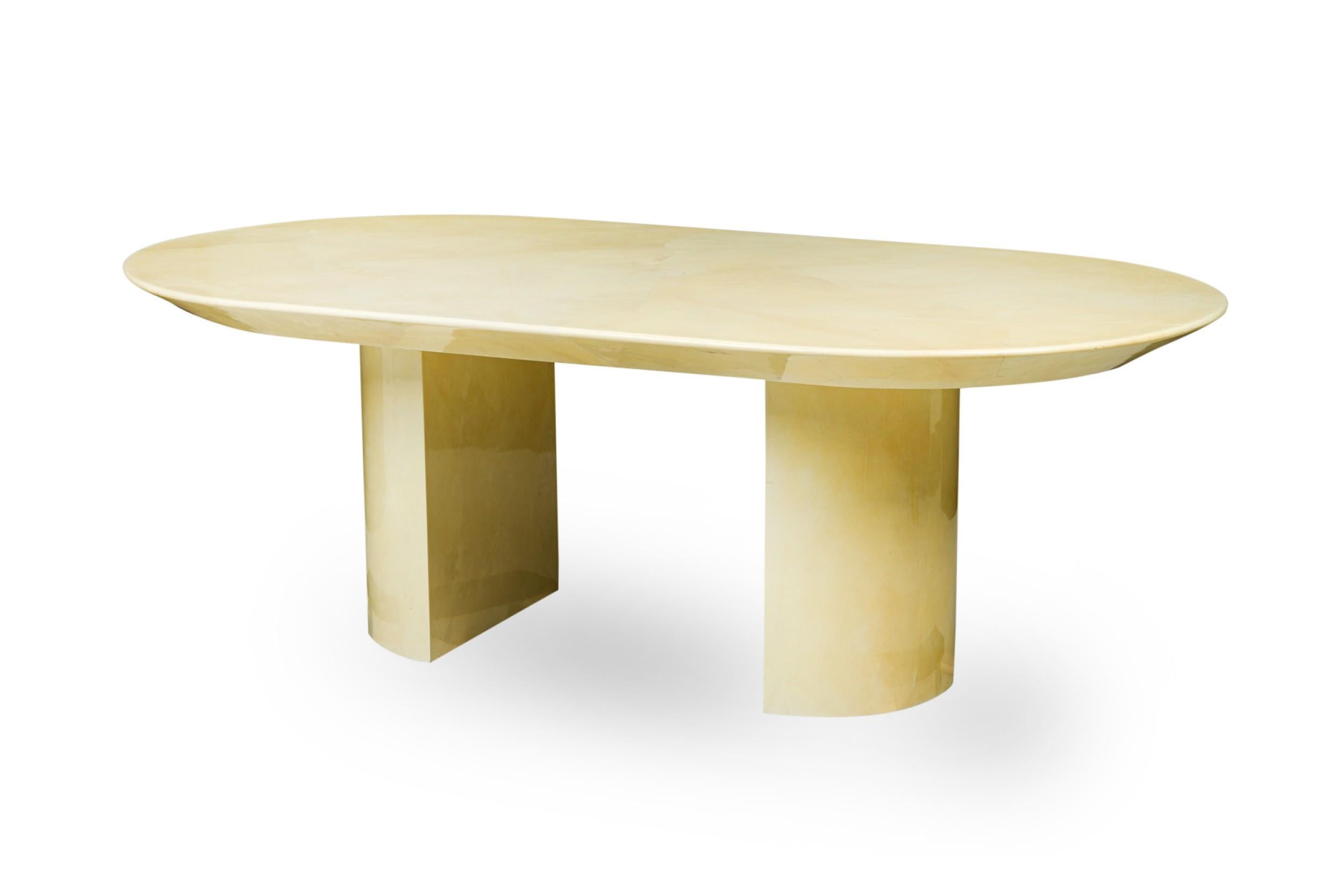 American Modern (1980s) dining / conference table with an oval top resting on two demilune bases, finished in a beige parchment / goatskin veneer. (KARL SPRINGER) (Similar piece: REG4031)

Condition: Good; Wear consistent with age and use