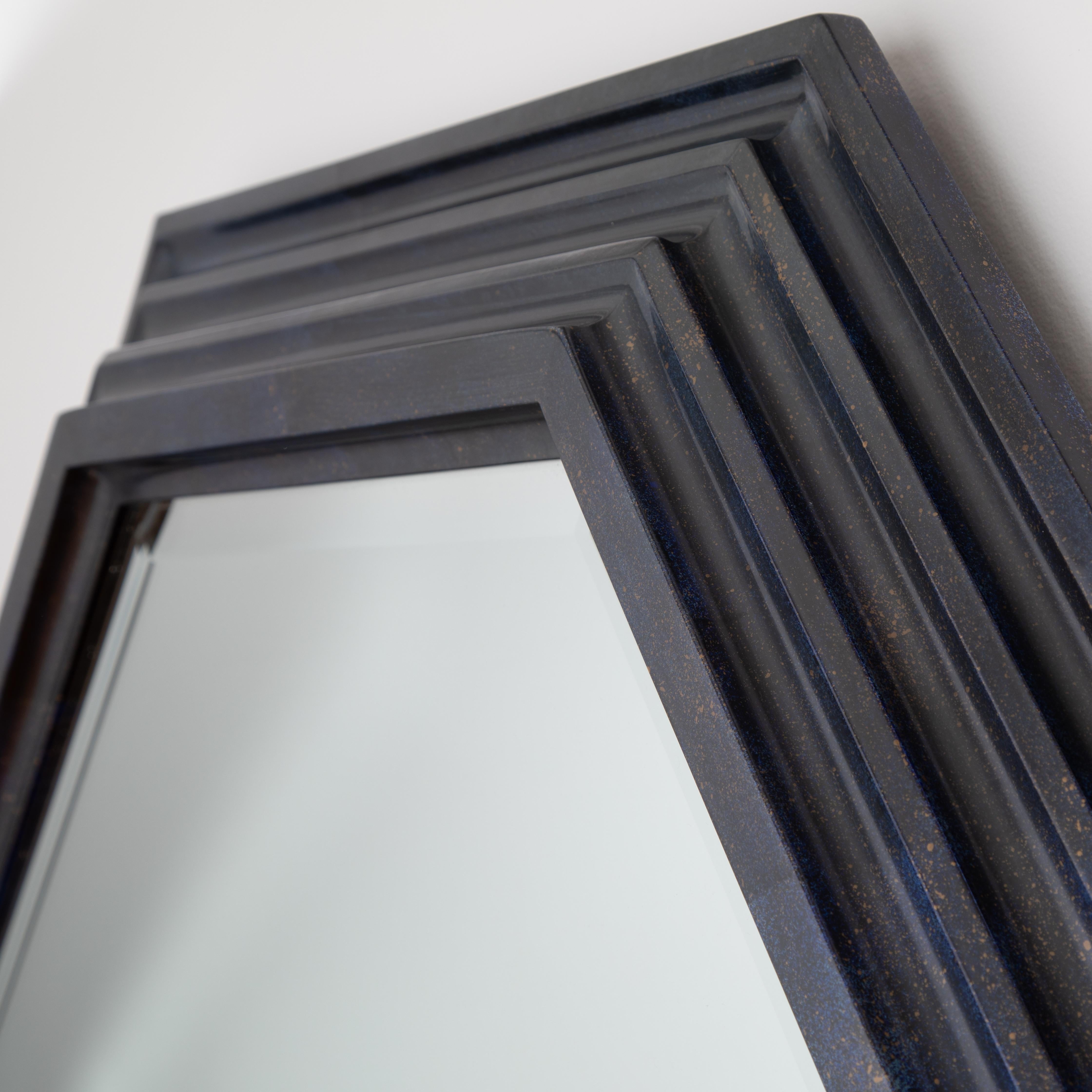 Gorgeous, grand-scale Karl Springer octagonal mirror with a deep, tiered wooden frame in a faux lacquer finish that mimics the semi-precious stone lapis lazuli. This deep-blue finish includes subtle faux seams where separate pieces of the 