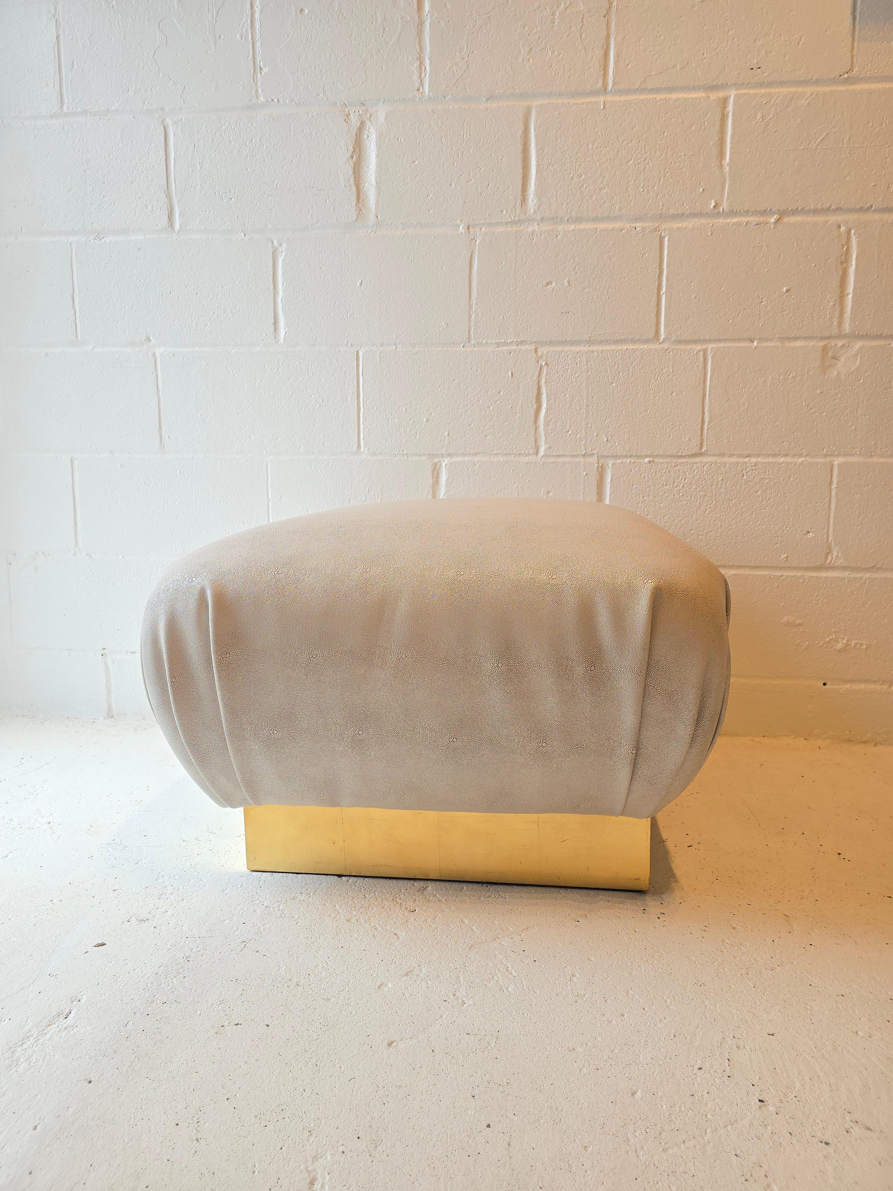 Uno splendido pouf pouf con un'esclusiva tappezzeria in finto zigrino e una base in ottone dorato. Questo pouf è attribuito a Karl Springer. Presenta una tappezzeria in finto zigrino di colore grigio meticolosamente lavorata e splendidamente piegata