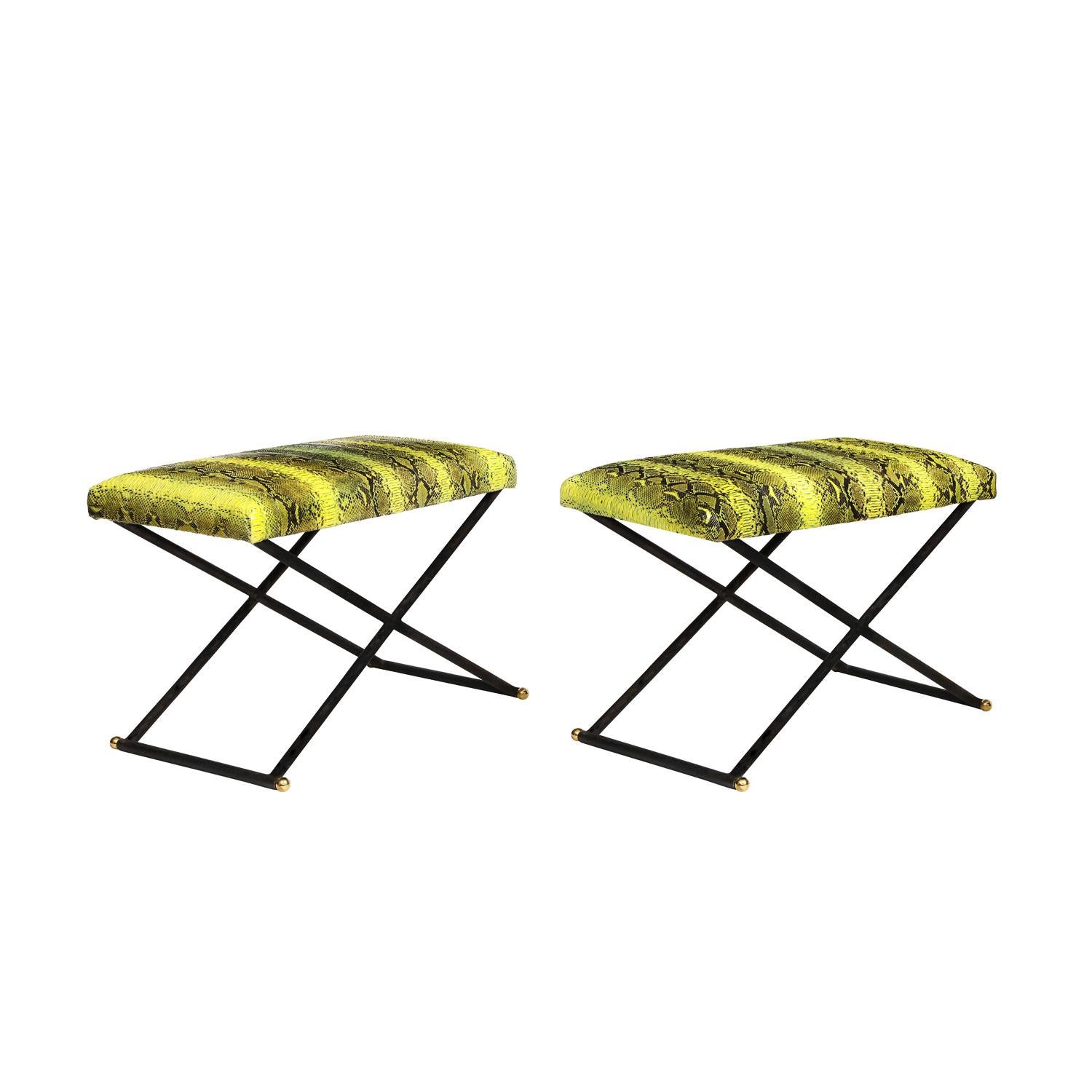 Pair of rare benches, X design in burnished steel with brass ball accents and seats upholstered in yellow and black python, by Karl Springer, American 1980's. The python seats are in excellent condition. The steel has been cleaned and professionally