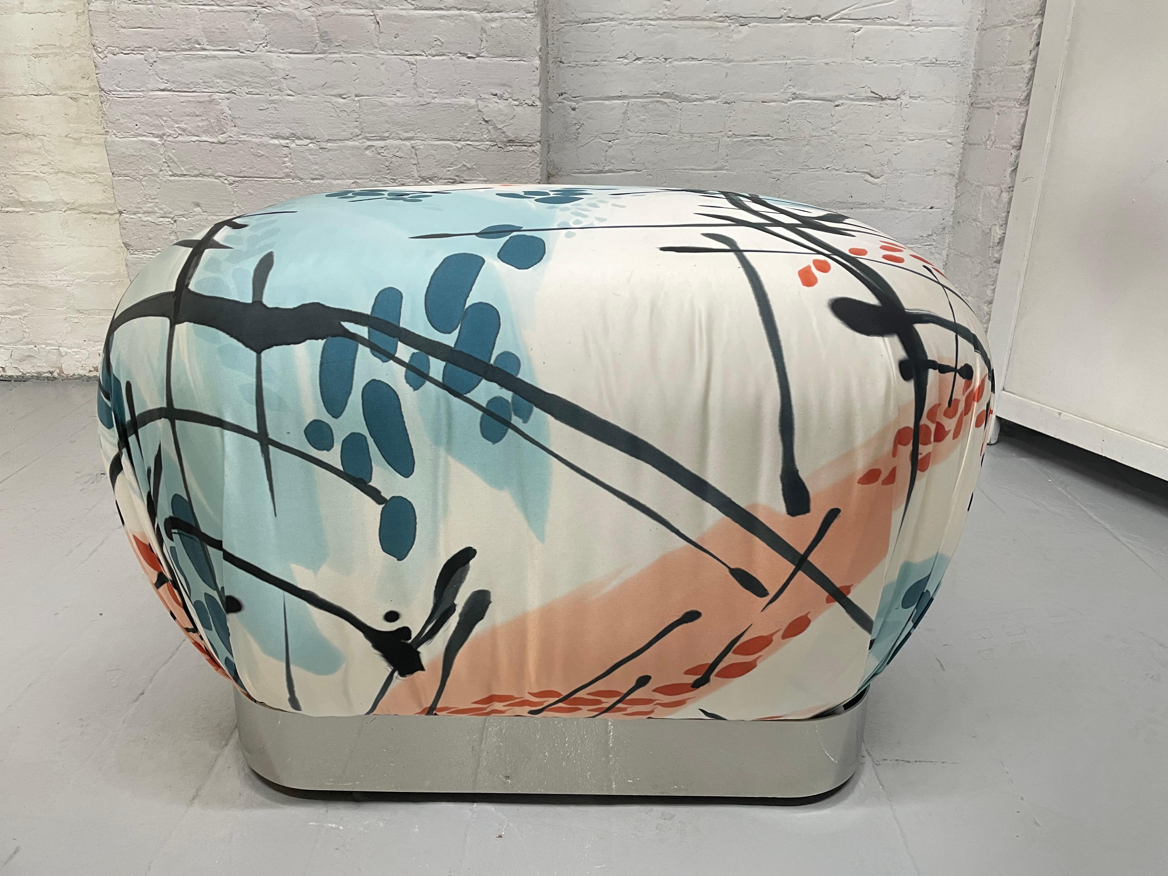 Pair of Karl Springer Souffle Ottomans / Poufs. The bases of the ottomans are brushed steel and upholstered in satin with a hand-painted abstract pattern by artist Michelle Li Murphy. The ottomans also have casters.