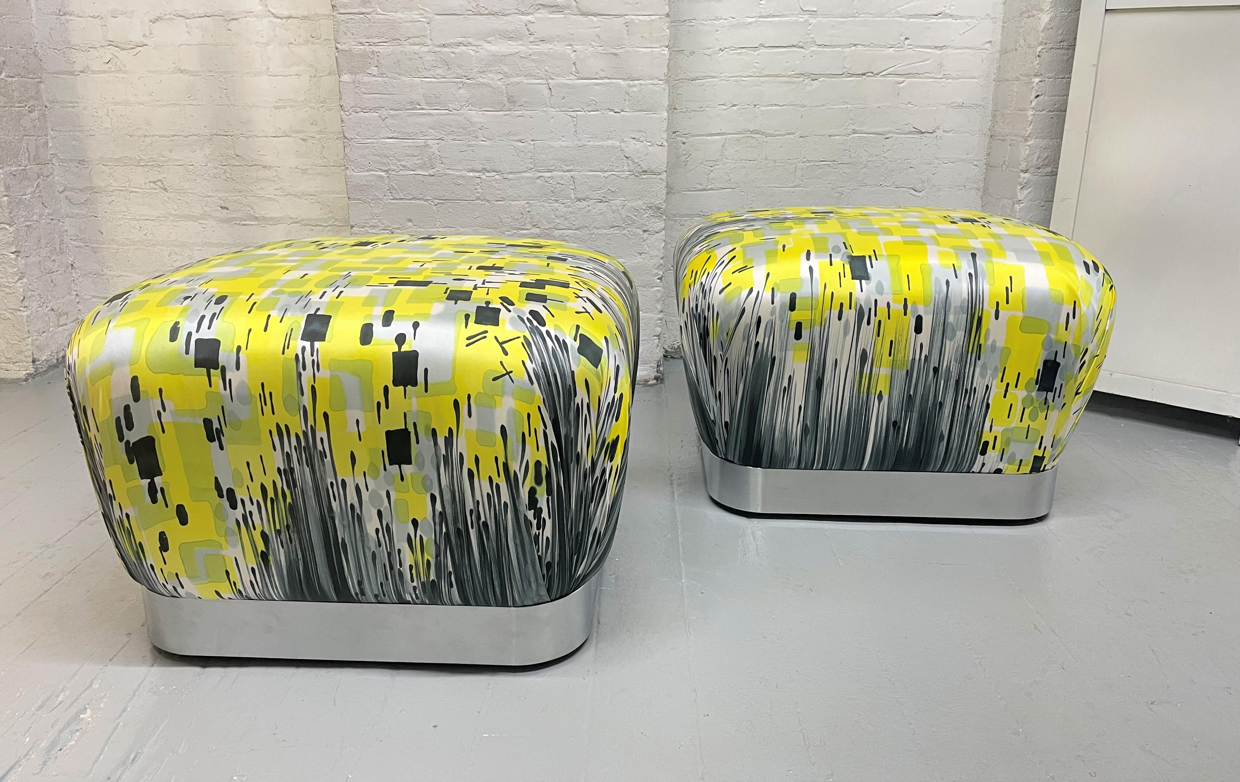 Pair of Karl Springer Souffle Ottomans / Poufs.  The bases of the ottomans are brushed steel and upholstered in satin with a hand-painted abstract pattern by artist Michelle Li Murphy.  The ottomans also have casters.