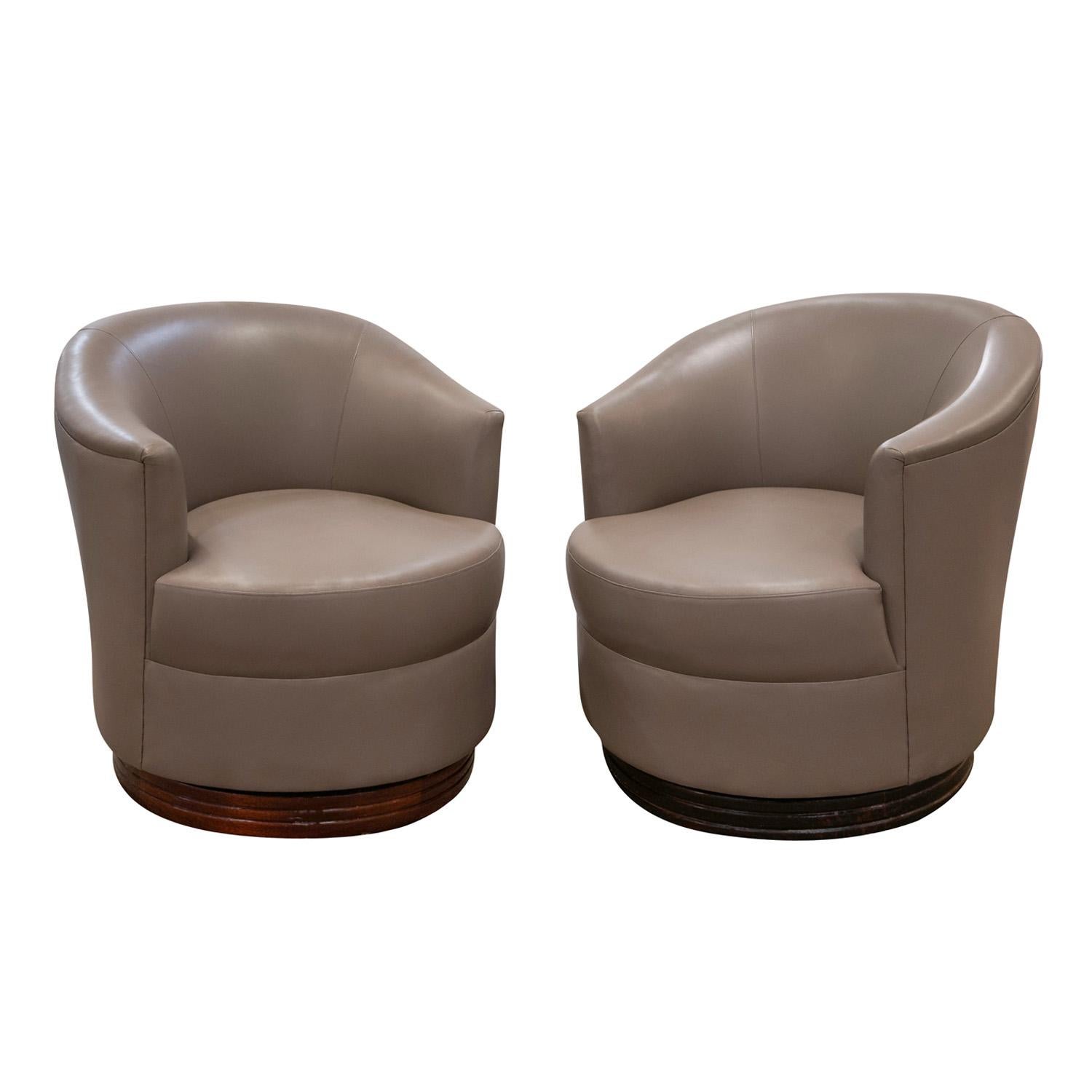 Pair of beautifully crafted swivel chairs with channeled solid mahogany bases by Karl Springer, American late-1980s. These chairs were recently reupholstered in taupe lambskin.  They are nicely proportioned and very comfortable.

Reference:
Karl
