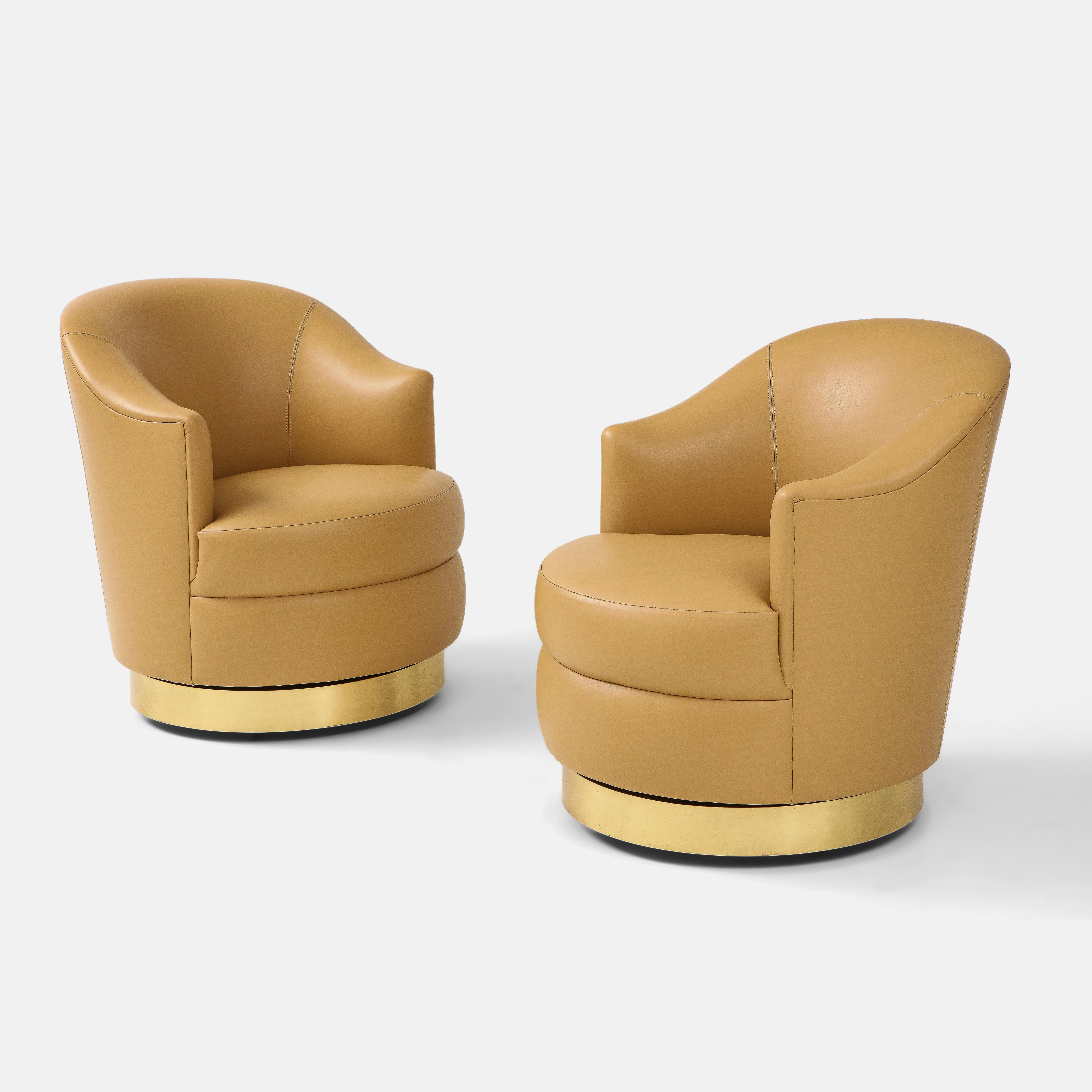 Karl Springer documented rare pair of swivel chairs in camel leather with brass bases, USA, 1980s. This incredibly chic pair of swivel chairs has been fully restored and newly reupholstered in Edelman camel leather. They have simple yet elegant