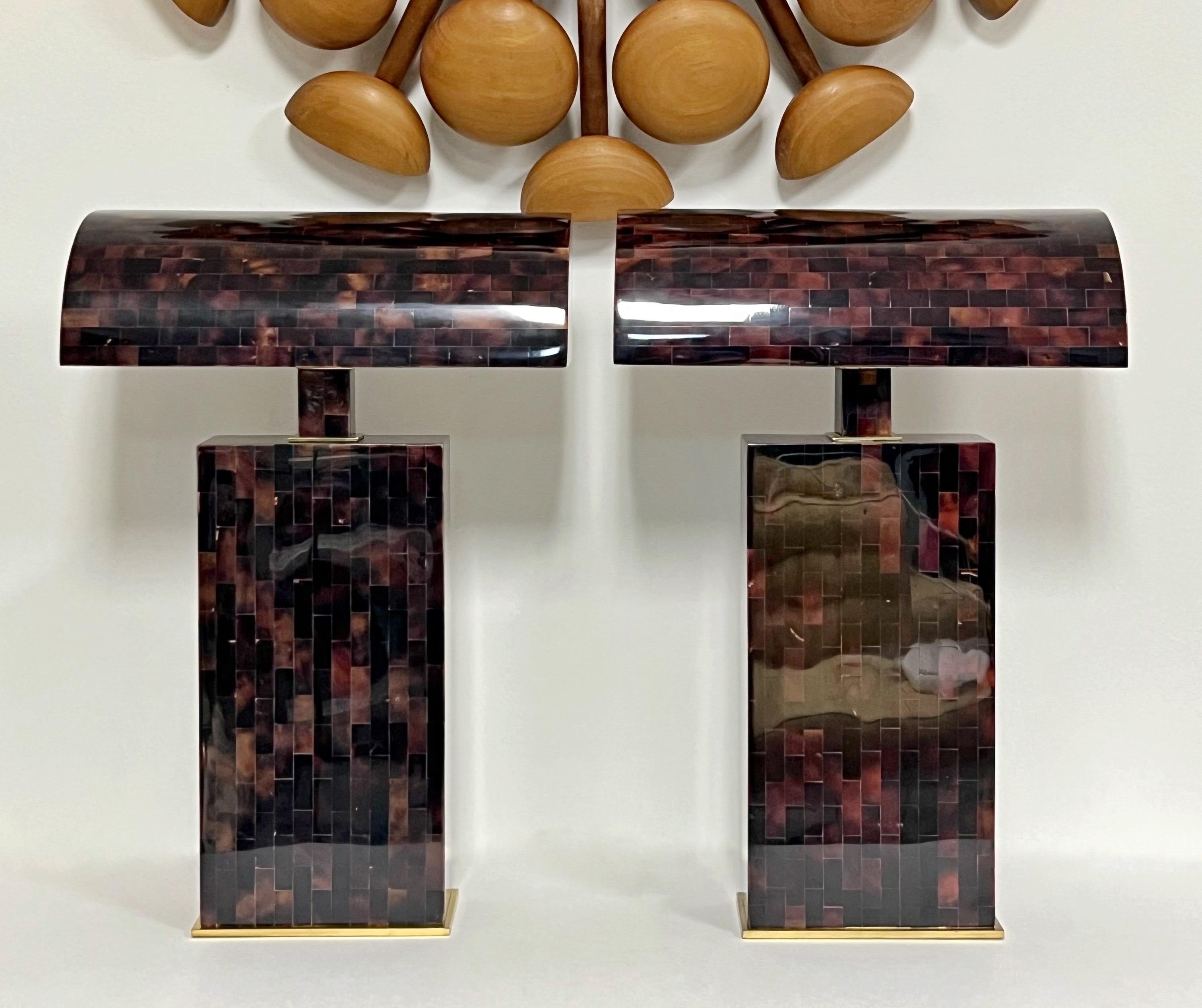 A pair of Karl Springer lamps. Completely done in tessellated penshell rectangles with a glossy polished finish. The look very closely resembles tortoise shell. Brass hardware. Each lamp has 2 regular sockets under the shade.