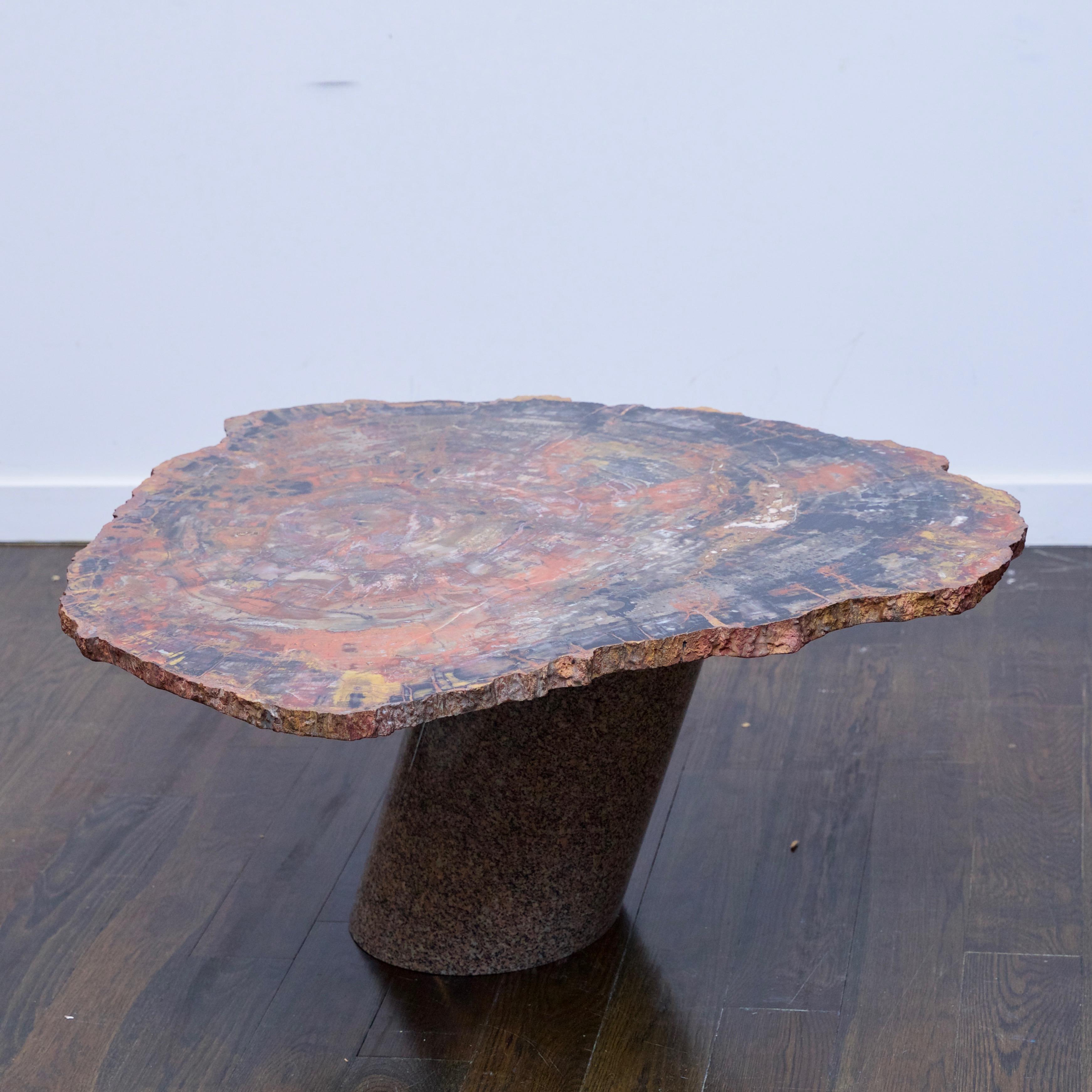 A petrified wood table top was purchased from Karl Springer for this custom piece by an unknown firm. Table is made from a cross section of petrified wood resting on a granite base.