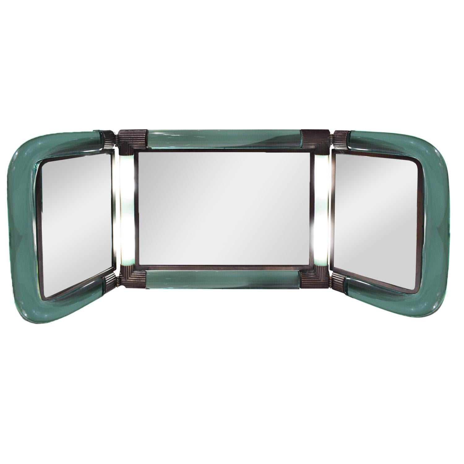 Exceptional and rare 3-part illuminating vanity mirror in hand blown green glass with artisan bronze fittings by Seguso (Murano Italy) for Karl Springer, American, 1980s (etched “KARL SPRINGER” in glass). Very few of these were made and the