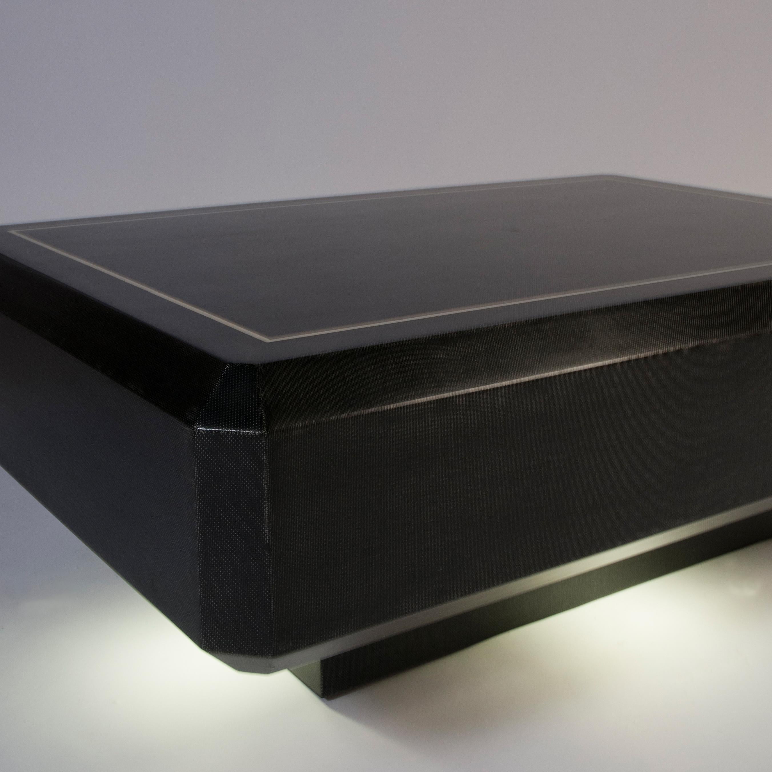 Faceted rectangular coffee table in black batik fabric with bone inlays, over pedestal base with recessed lighting, by Karl Springer, American 1970's. The recessed lighting makes this table really cool.