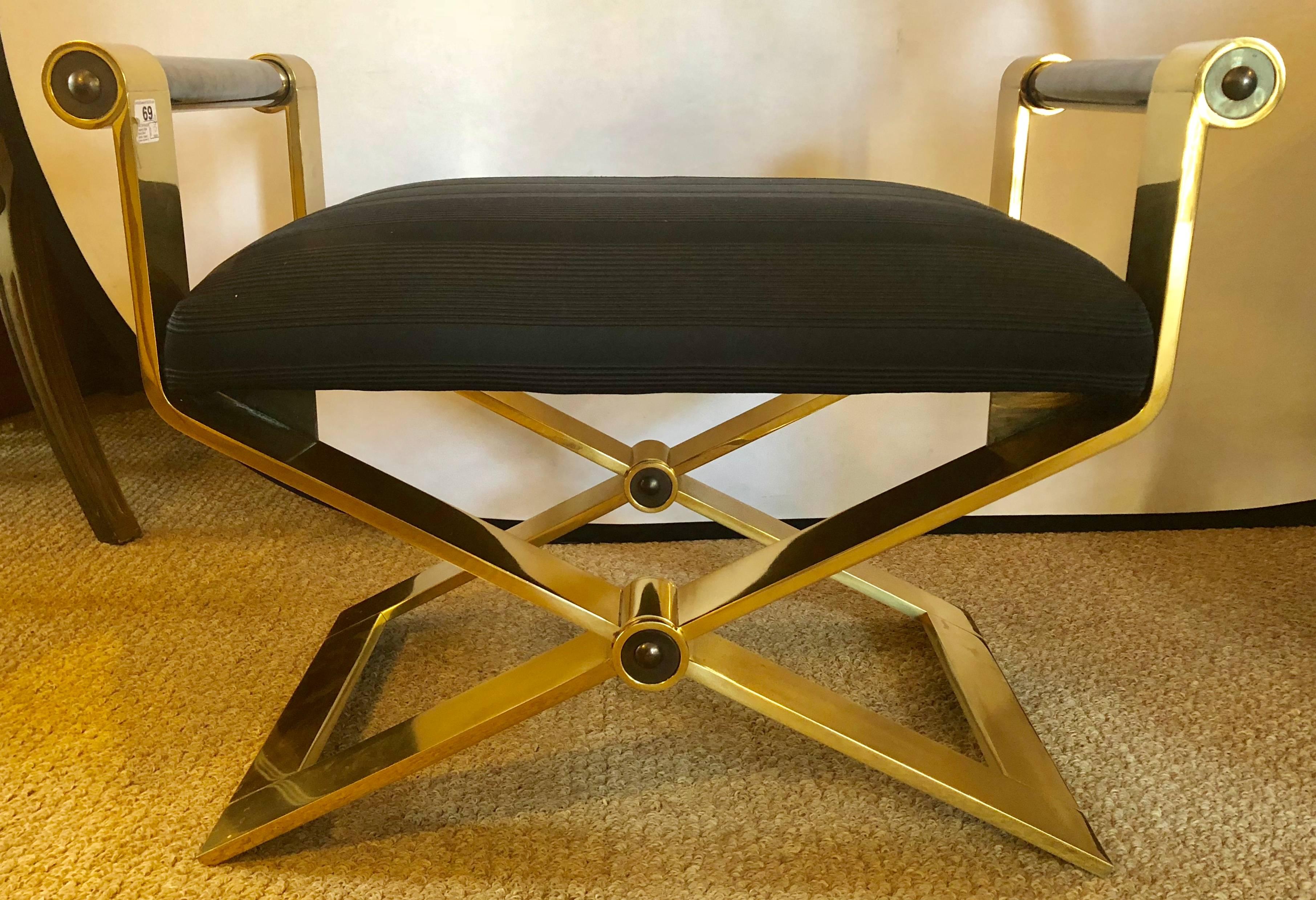 This regency style brass stool bench by designer Ron Seff for Karl Springer. is simply the finest by this iconic designer. Heavy brass modern X-base and ebony construction. Gunmetal metallic finish arm with a Black fabric seat. Unmarked. Dimensions: