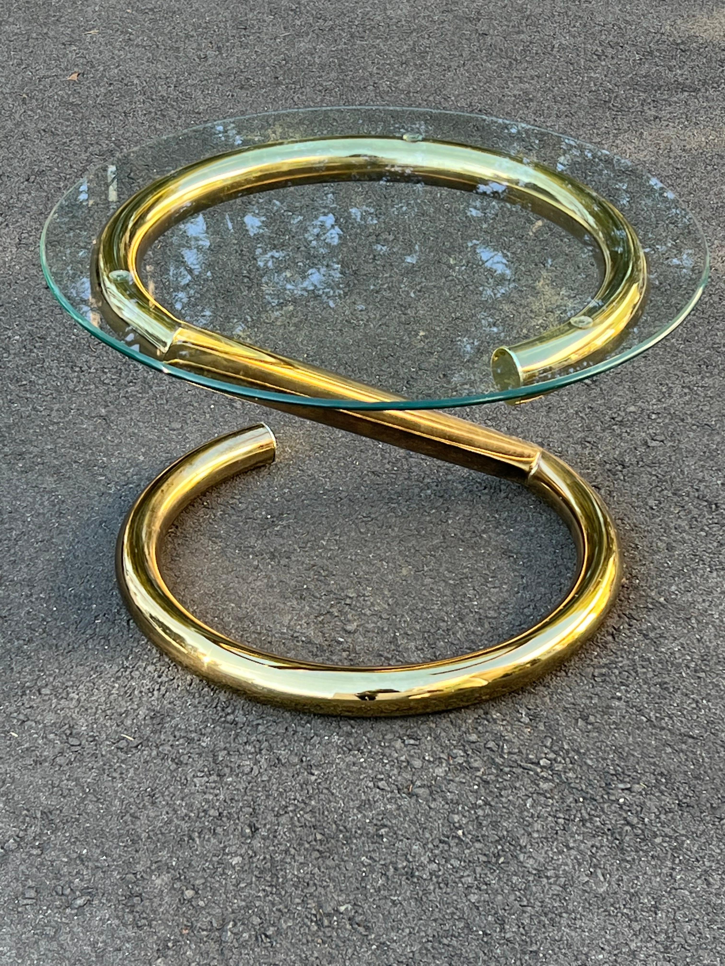 Karl Springer style round “Z” table in brass. Nice open geometric design. Two pieces. 
Perfect as a side table or small coffee table. Two pices. Glass removeable for easy transport. The base can easily be parcel shipped if you want to purchase