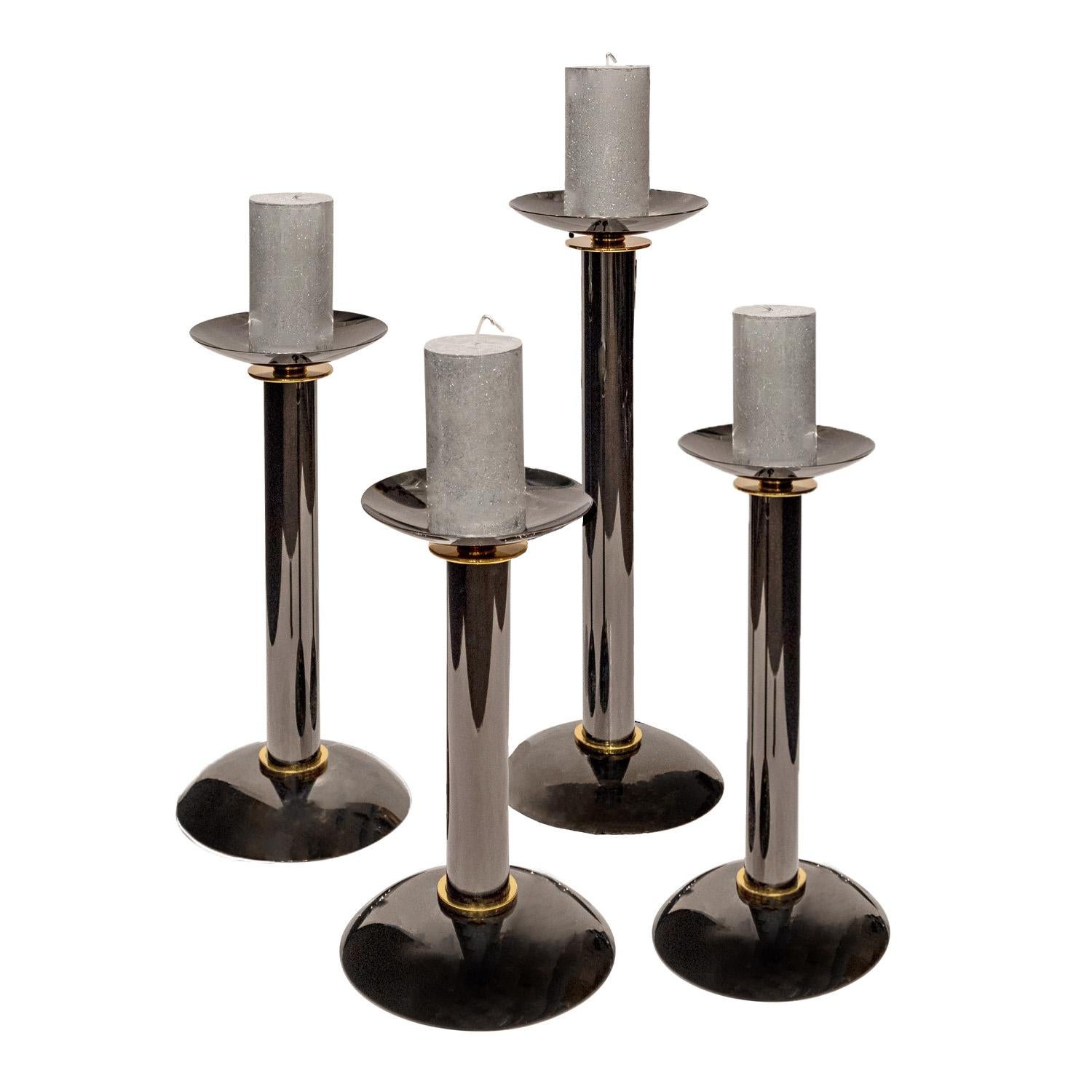 Set of 4 candle holders in polished gunmetal with brass accents by Karl Springer, American 1980s. These iconic Springer candle holders are the epitome of chic.

Reference 
Karl Springer Red Binder Catalog, published in the 1980’s, Section