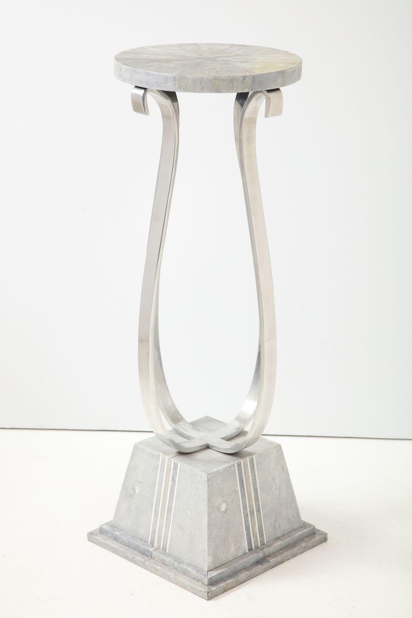 Un pedestal de piel de zapa maravillosamente elaborado, con una base cuadrada escalonada y cuatro brazos enrollados de estilo Art Déco que terminan en una tapa circular cubierta de piel de zapa H: 43 pulg: An: 15 pulgadas D: 15 pulgadas
